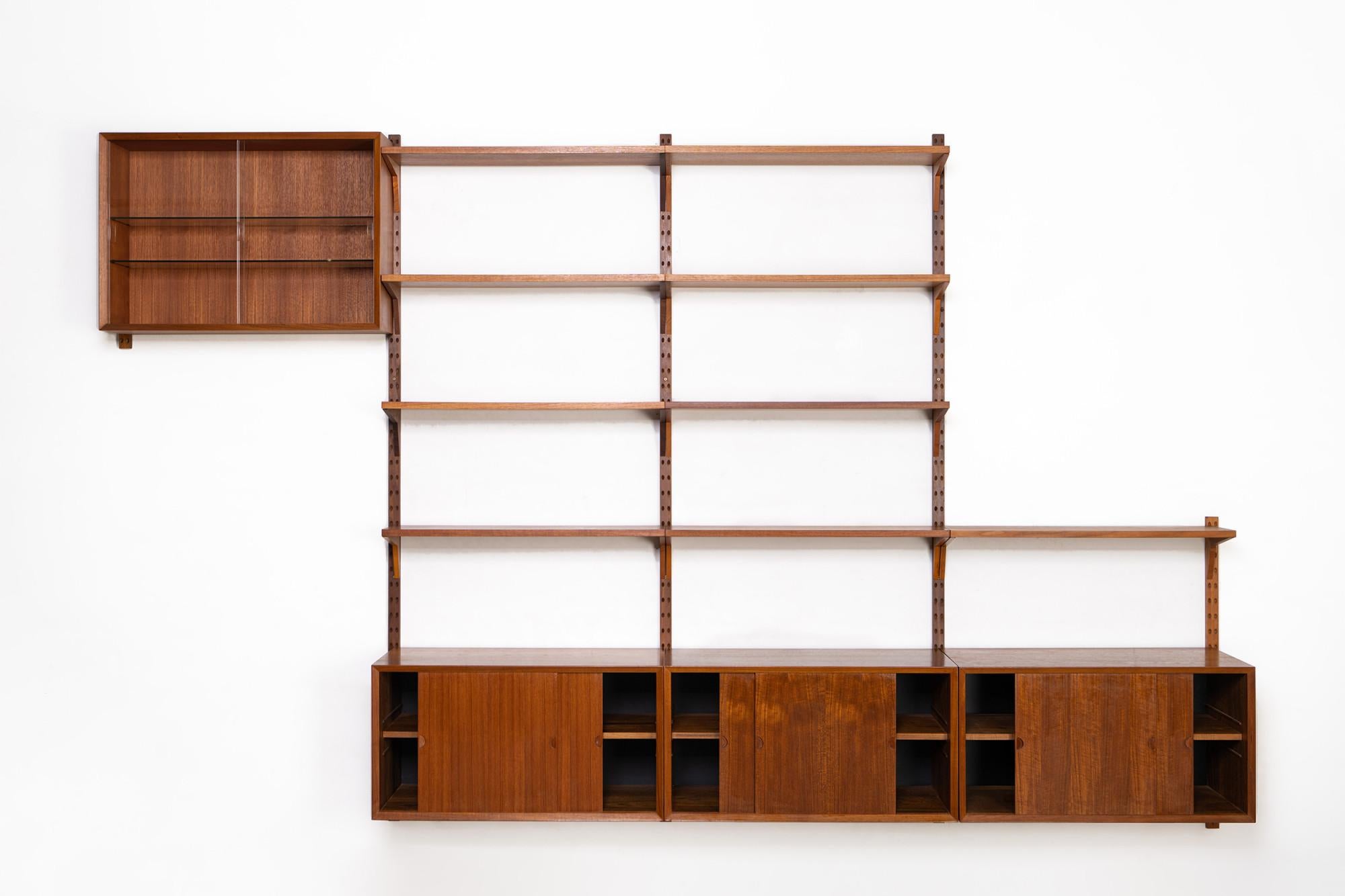 Danish modular wall unit by Poul Cadovius for Cado. This teak setup has three storage cabinets, one display cabinet and nine bookshelves. Always adaptable and further expandable.