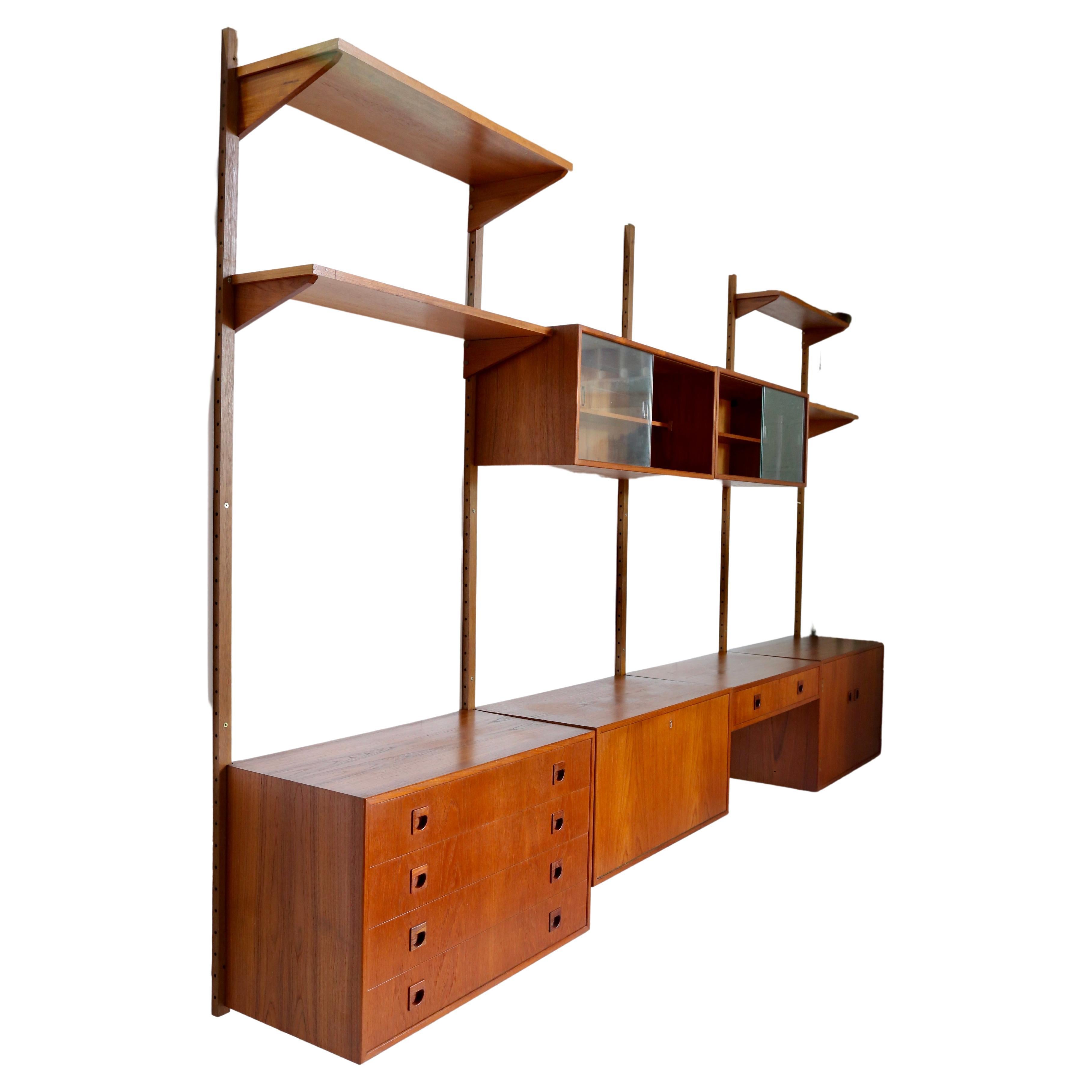 A remarkable and functional Danish Mid Century Modern wall unit, designed by Rud Thygesen and Johnny Sorensen for HG Furniture (Hansen and Guldborg) Denmark, 1960s. The complete modular unit comes with five wall-mounted uprights, six cabinets, one