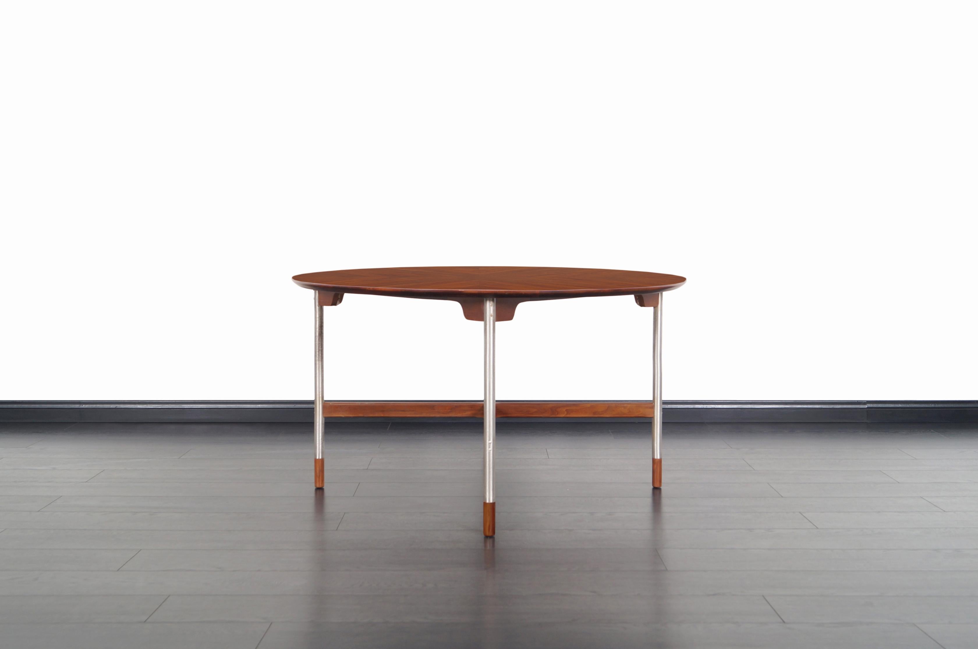Erstaunlicher Mid-Century Modern Tisch von Jack Cartwright für Gründer in den Vereinigten Staaten, ca. 1960er Jahre. Mit einer Platte aus Walnussholz in Buchform, einer X-förmigen Streckung und gebürsteten Stahlbeinen mit Kappen aus massivem