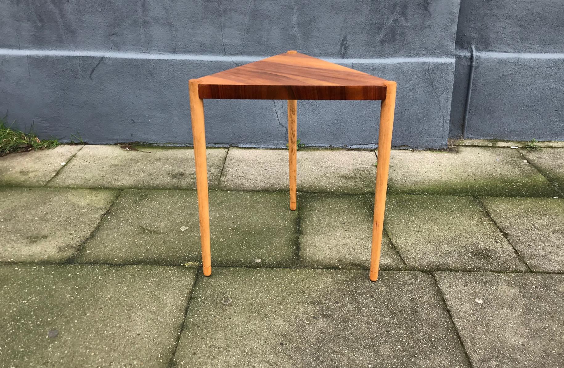 Small triangular side or lamp table from Edmund Jørgensen. Manufactured in Denmark during the 1960s. It features round solid oak legs and a tabletop executed with walnut veneer. Its is stamp pat. applied to the underside.
