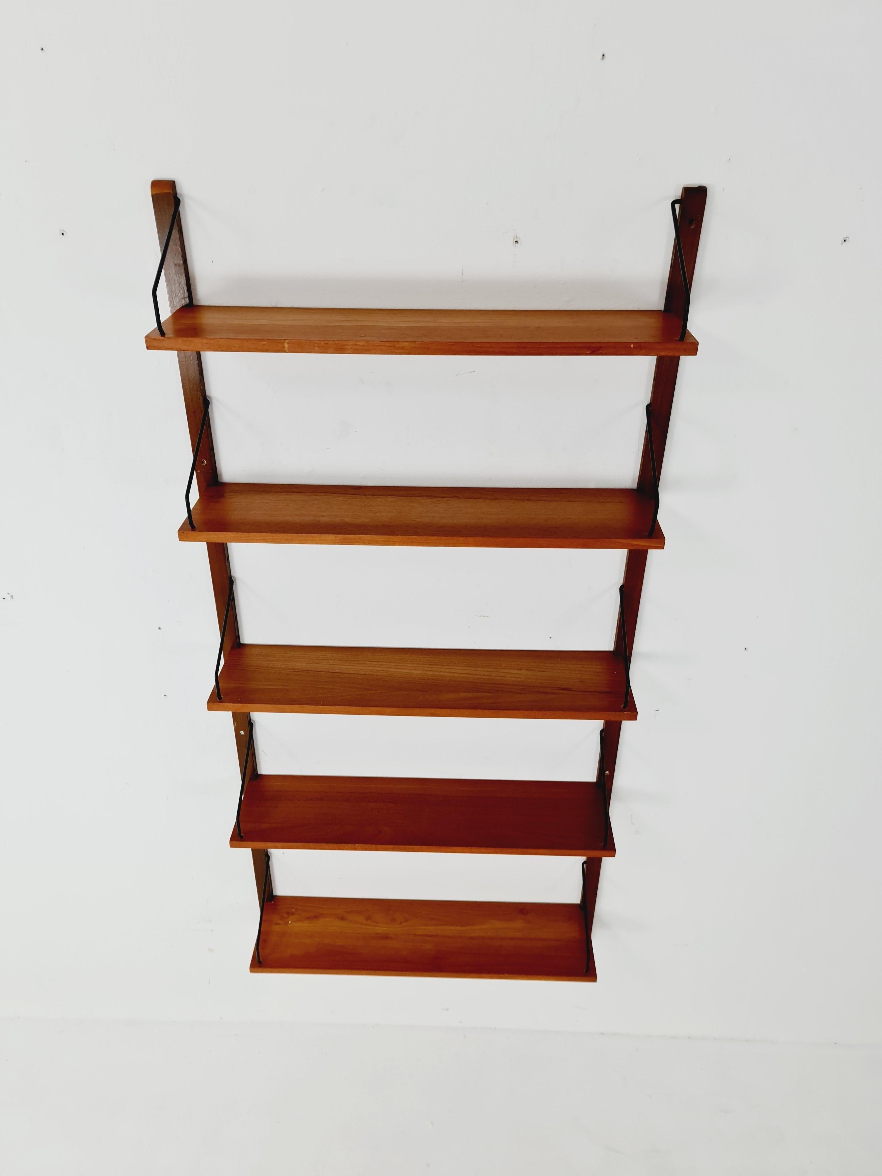 Midcentury Danish walnut Wall-Mounted Shelving Unit, by Royal for  Poul Cadovius, 1960s

Once the wall mounted brackets are fixed. The brackets have holes in the sides that each shelf support fits into, and you can hang this entire system easily and