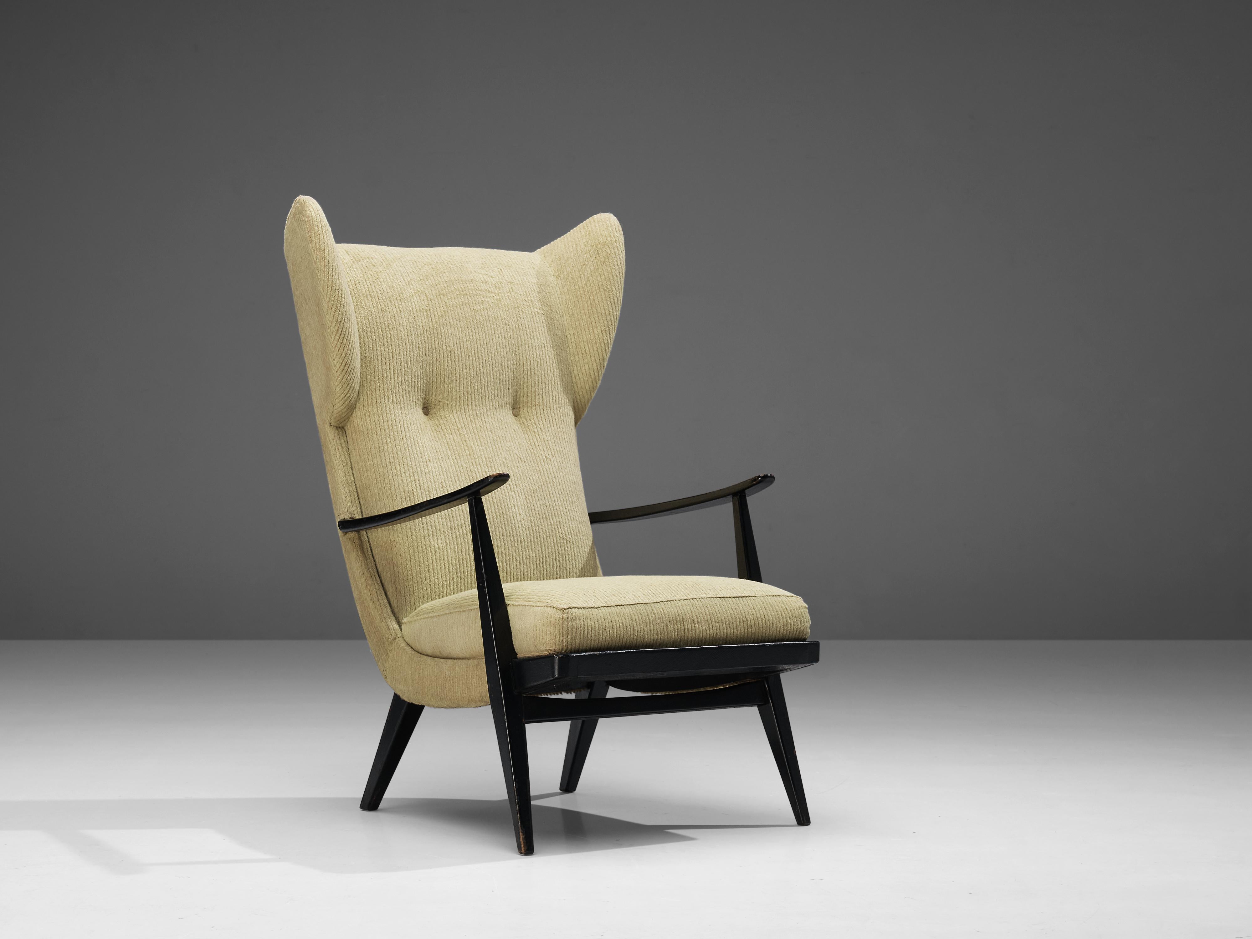 Wingback chair, fabric, stained wood, Denmark, 1950s

Danish wingback chair with elegant armrests in dark stained wood. The design of the frame and the tapered legs matches perfectly with the thick seat cushion and the backrest with tufted details.