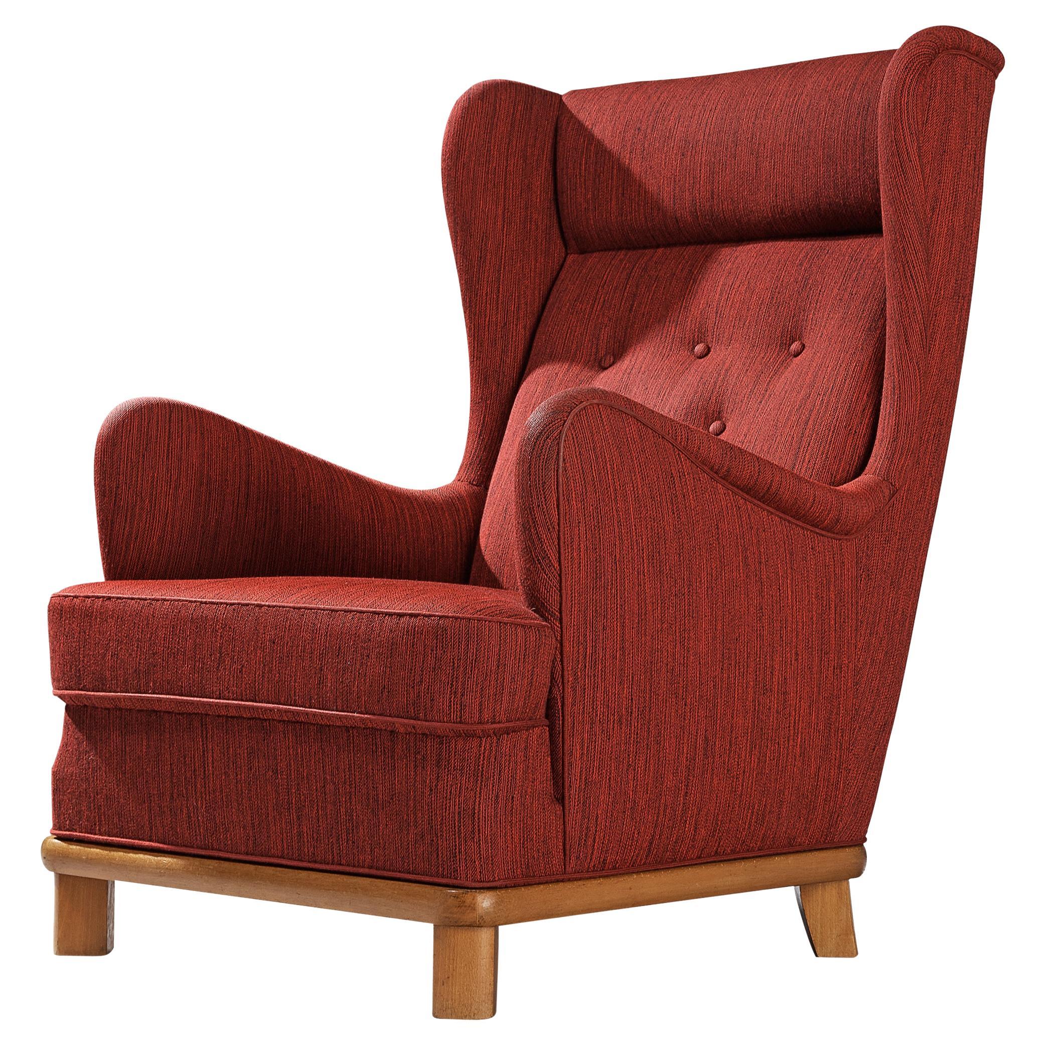 Easy chair, fabric, beech, Denmark, 1950s

This archetypical wingback chair of the 1950s is both extremely comfortable and pleasing to the eyes. The armchair is upholstered in a fine textured fabric, showing a mixture of black and red lines. The