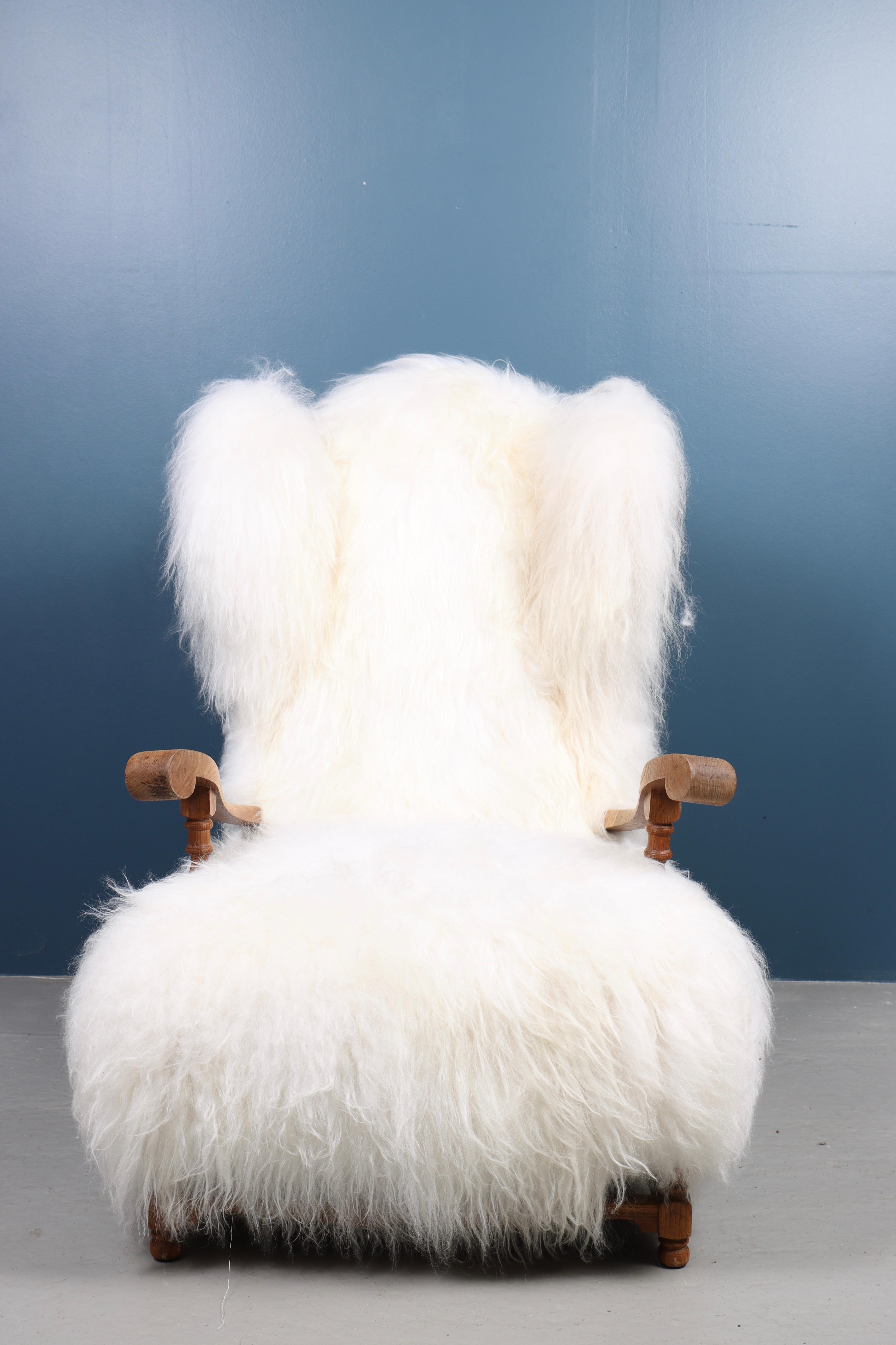Lounge chair upholstered in solid oak and sheepskin. Designed and made in Denmark.