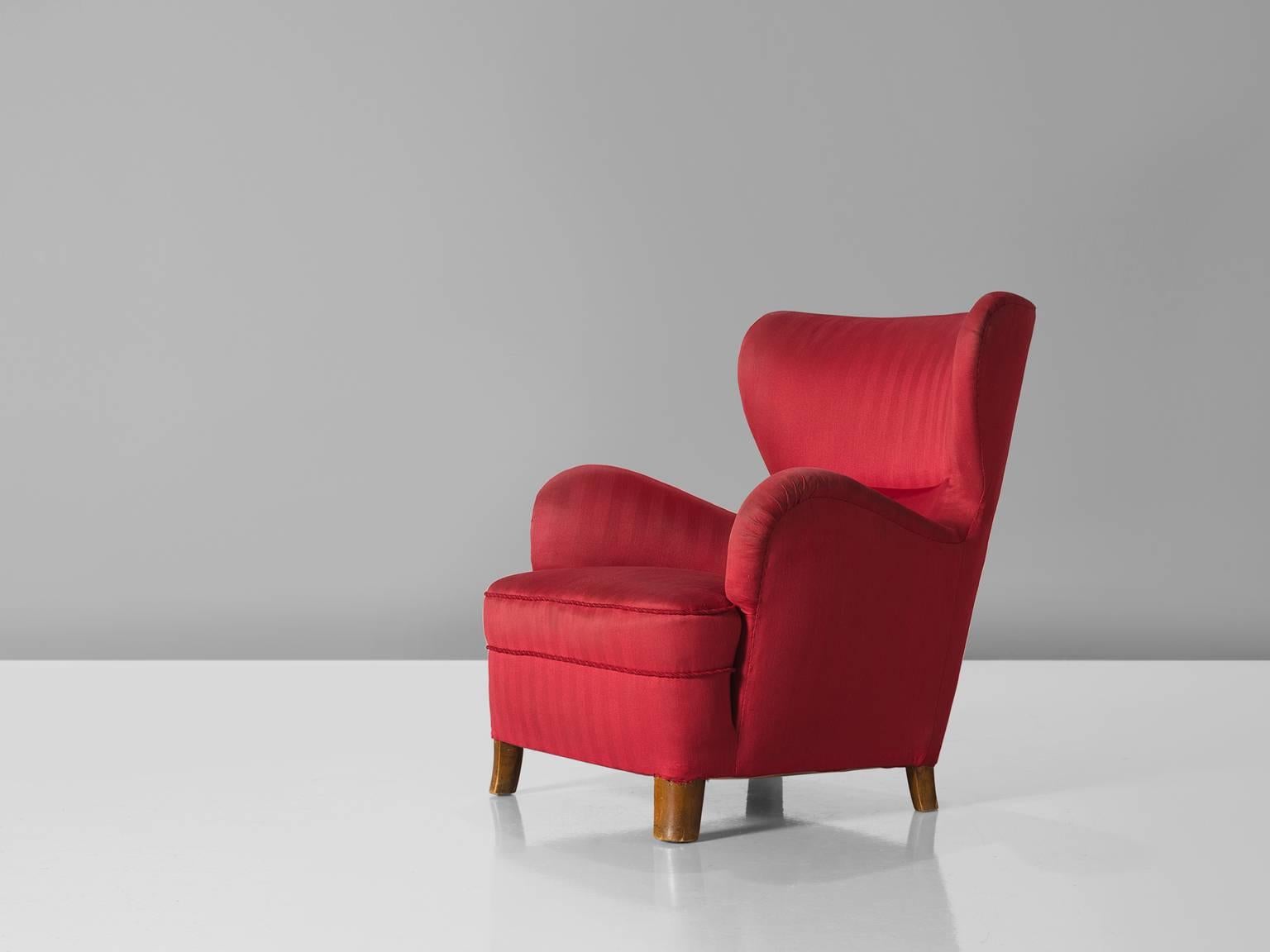 Sessel, roter Stoff, Buche, Dänemark, 1950er Jahre

Dieser schöne und bequeme dänische Stuhl ist mit kleinen Flügeln und einer geschwungenen Armlehne ausgestattet. Dank der üppigen Armlehnen erhält der Stuhl eine charakteristische, lustige Form.