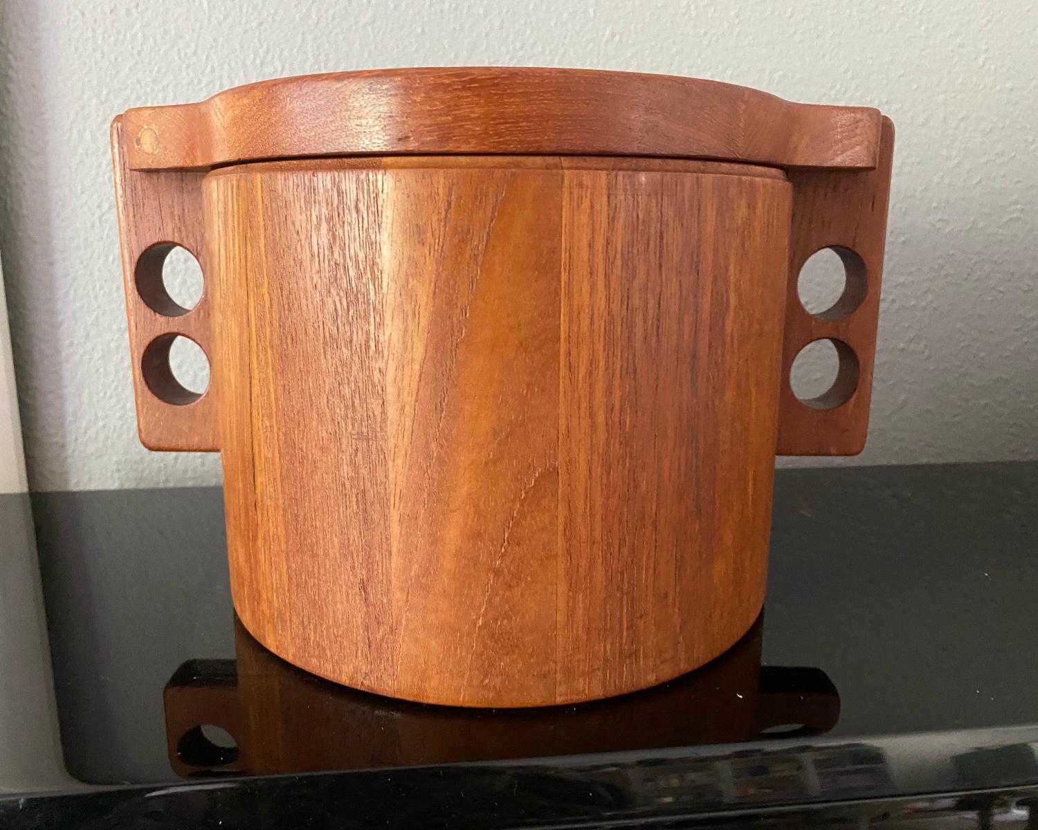 Beautiful solid teak ice bucket with plastic bucket/bowl inside, the two handles on
each side create a beautiful symmetry.
The hallmark of the company and the country name Denmark is on the bottom.
   