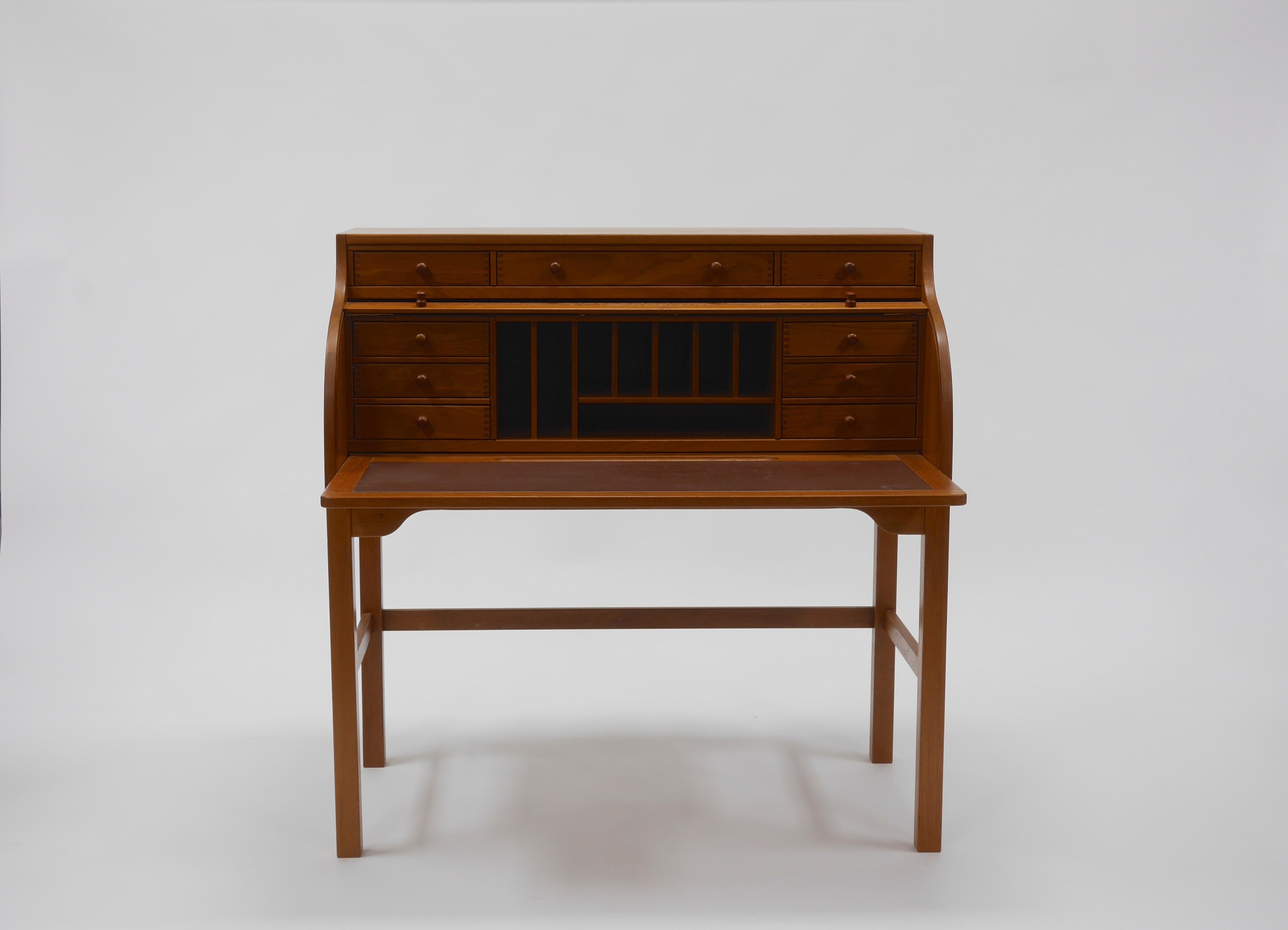 Andreas Hansen roll top teak desk, manufactured by Form75 in Hadsten, Denmark.
Featuring a locking tambour roll top concealing a fitted superstructure and a pullout / pull-out leather writing surface. 

Measures: 44