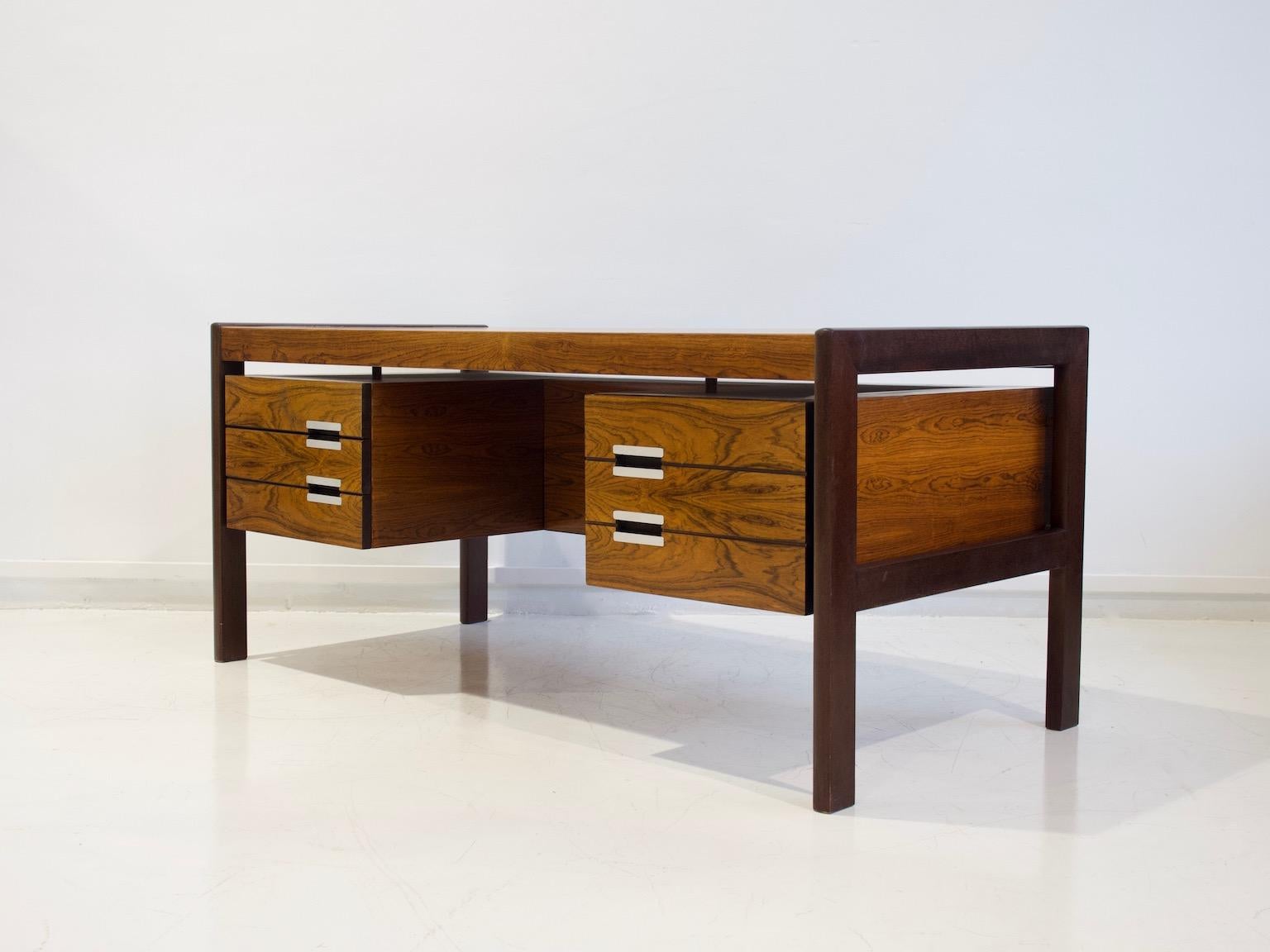 Writing table made of veneered hardwood by Dyrlund Smith, Denmark, in the 1960s. Fitted with one large and three small drawers with aluminum handles. There is a shelf at the back of the table. Labeled by manufacturer.