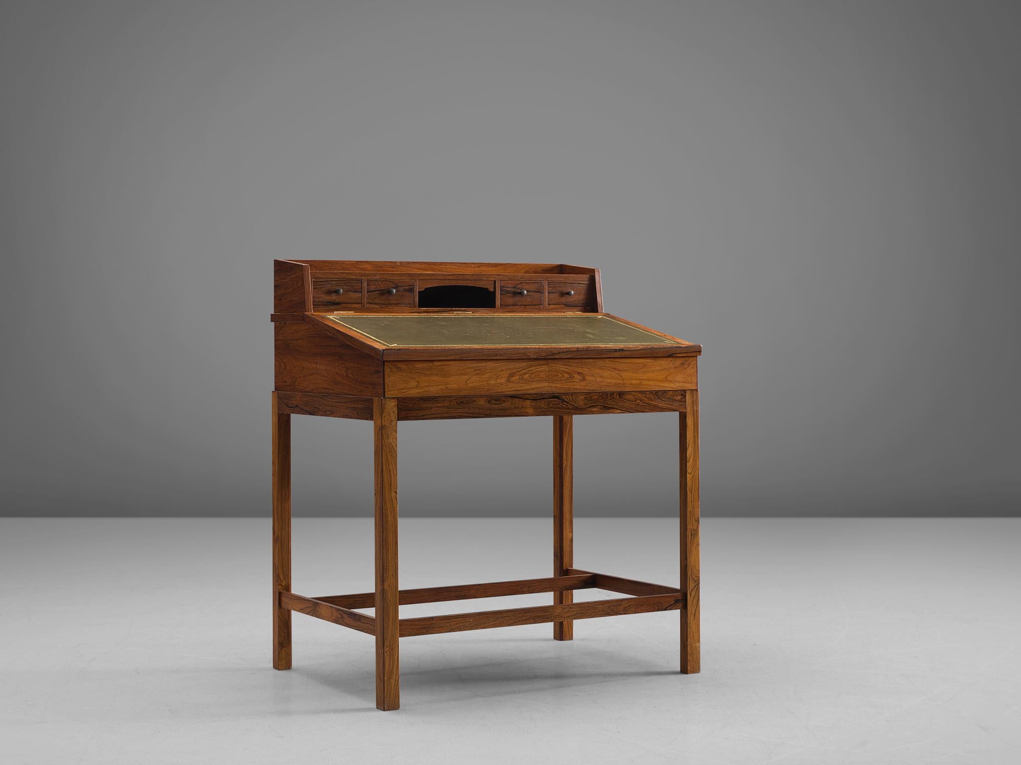 Secretaire, rosewood with olive green leather inlay, Denmark, 1940s

This Danish writing table has an inclined writing surface with a green leather inlay and a golden decorative frame. This part can be opened and used for storage. Furthermore four