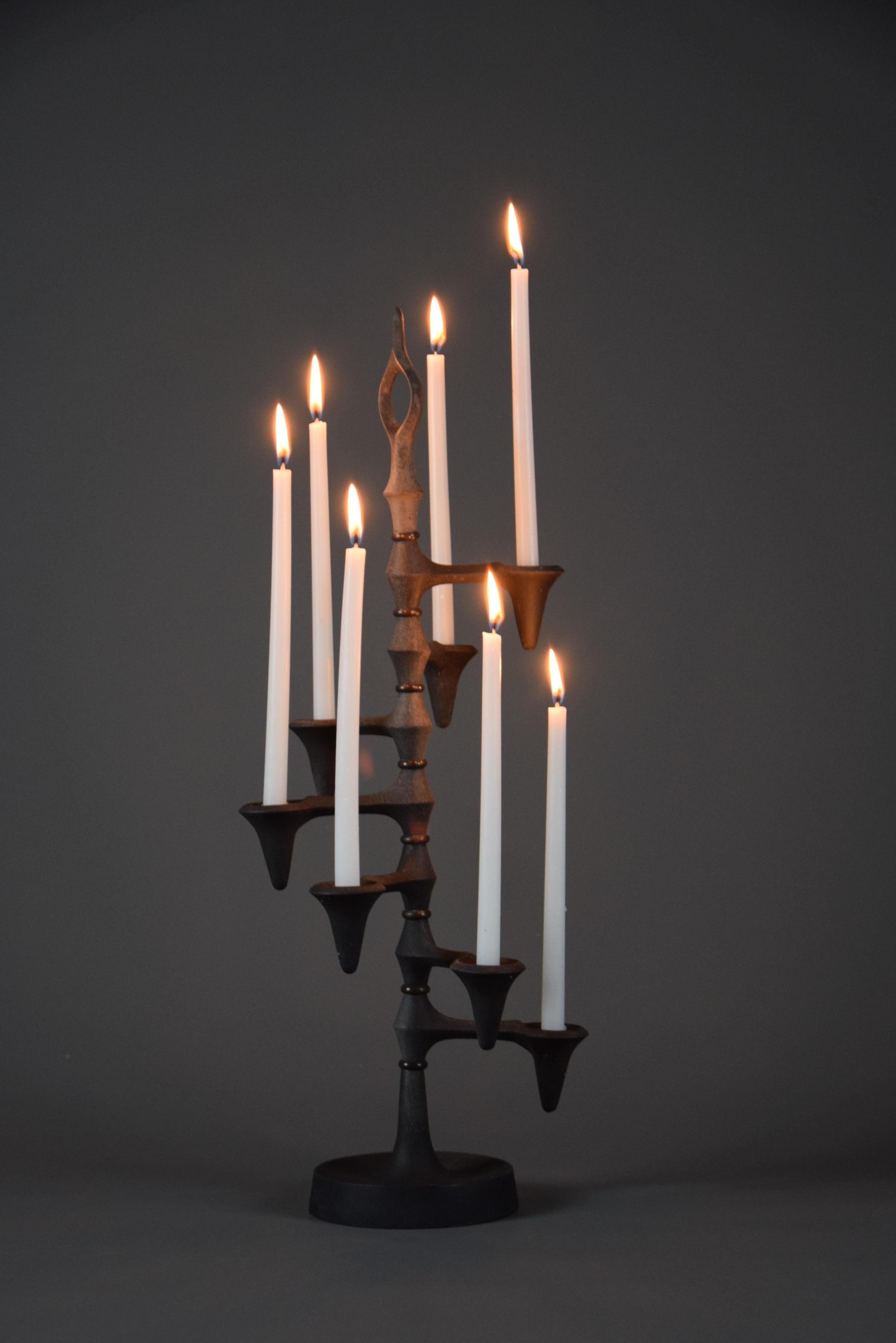 Entra nell'eleganza senza tempo del design di metà secolo con questo raffinato portacandele da tavolo in ferro battuto degli anni '60, progettato dal leggendario Jens Quistgaard per Dansk Designs, Danimarca. Questo capolavoro scultoreo vanta sette