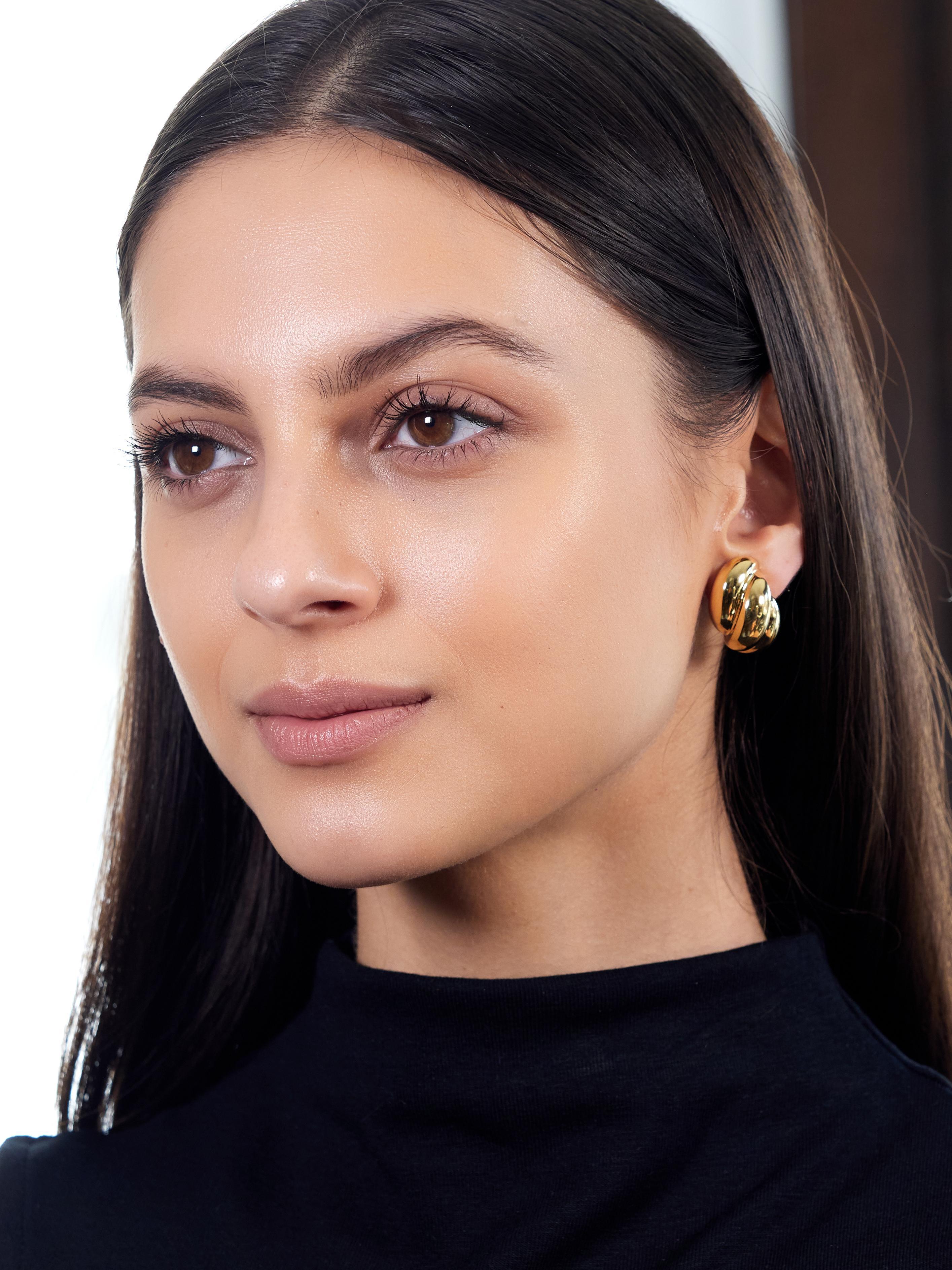 Diseñadas como estilizadas formas doradas abovedadas
Acanalado con detalle de motivo de giro abullonado
Con acabado pulido
Completados por respaldos omega abatibles
Estampado para oro de 18 quilates
Totalmente firmado por Dankner
Circa: años