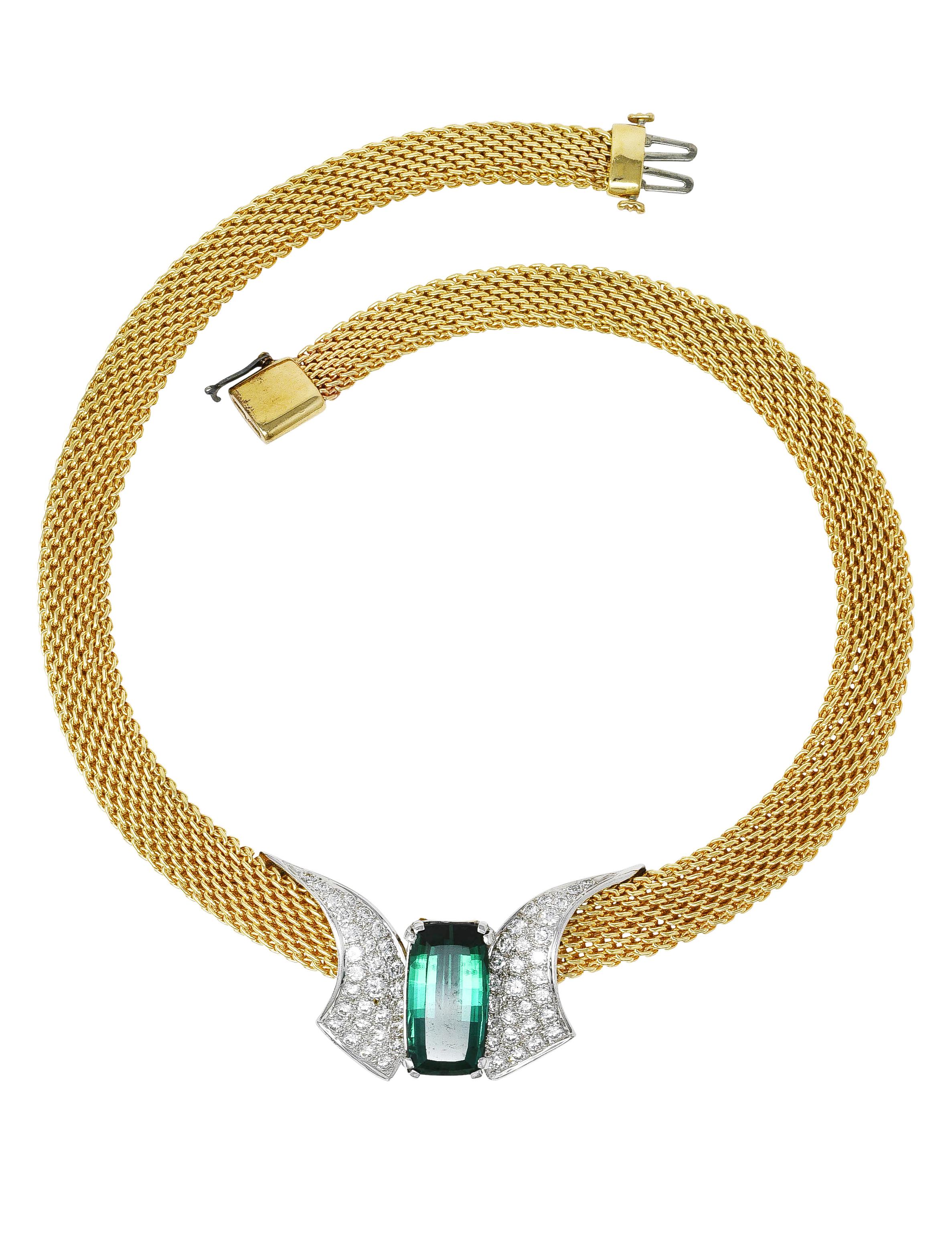 Designed as a woven mesh yellow gold chain graduating in size and centering a curling white gold station. Featuring an elongated mixed cushion cut tourmaline weighing approximately 7.97 carats total. Transparent bluish-green to green in color with