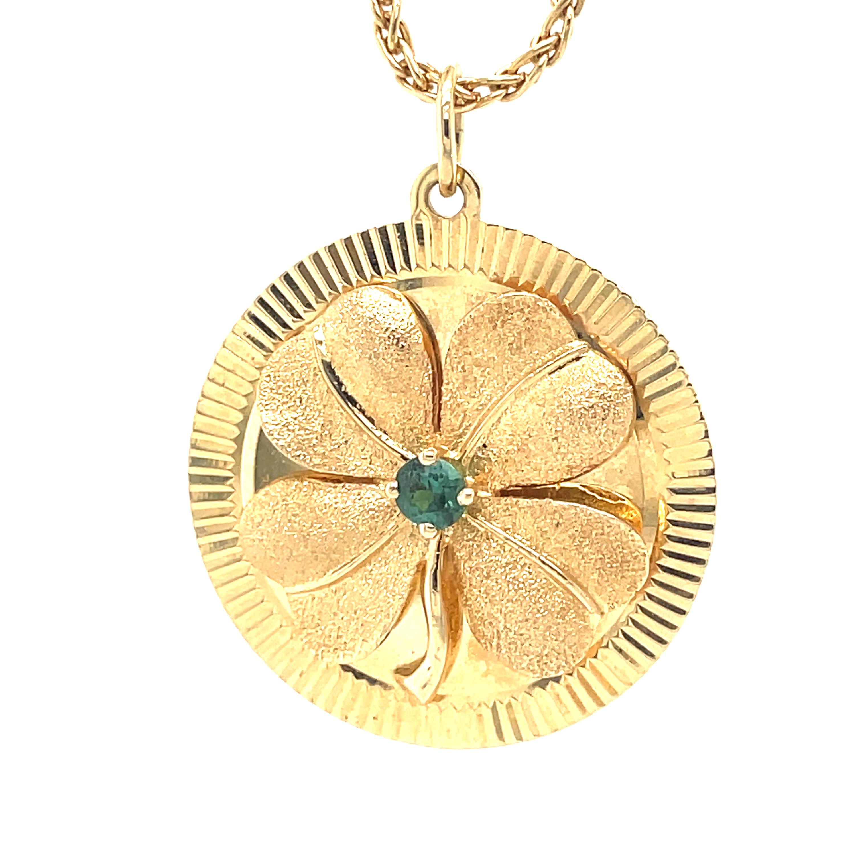 Superb good luck charm:  a three-dimensional four-leaf clover, set with a brilliant green tourmaline.  14K textured yellow gold.  Within a shiny 14K yellow gold.border, engraved in a fine line pattern.  Made and signed by HENRY DANKNER & SONS.  Very