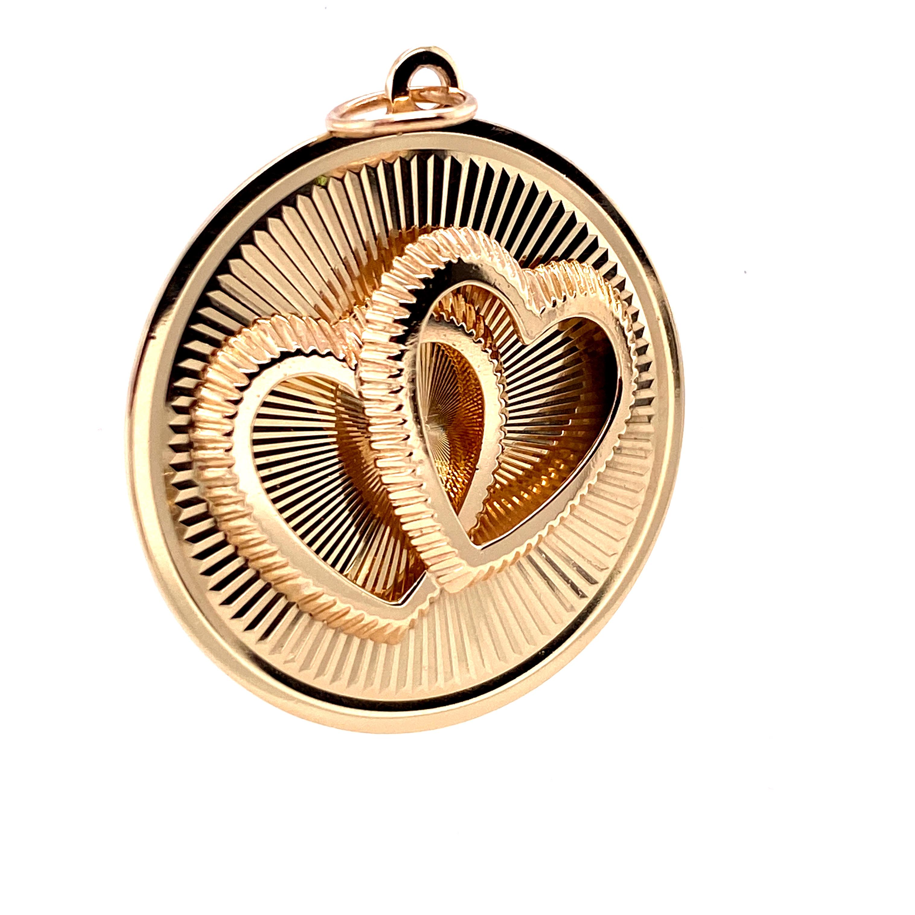  Romantic double-heart charm.. Made and signed by HENRY DANKNER & SONS.  Two three-dimensional intertwined fluted hearts applied on a background of  engraved rayed lines.  14K yellow gold.  Never engraved.  In pristine condition. 1 1/8