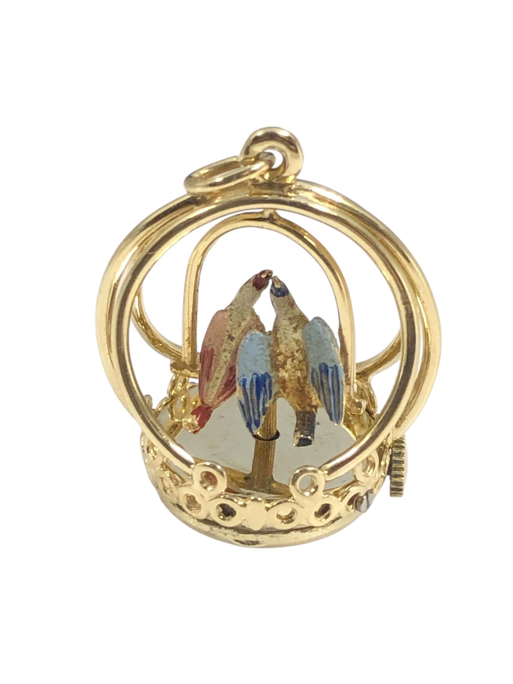 Circa 1960s Henry Dankner 14k Yellow Gold mechanical Love Birds Charm, measuring 1 1/4 inches in height X 1 inch wide and weighing 12.2 Grams. The Enamel decorated Birds Spin on their perch when wound by the crown, a mechanical, modified watch