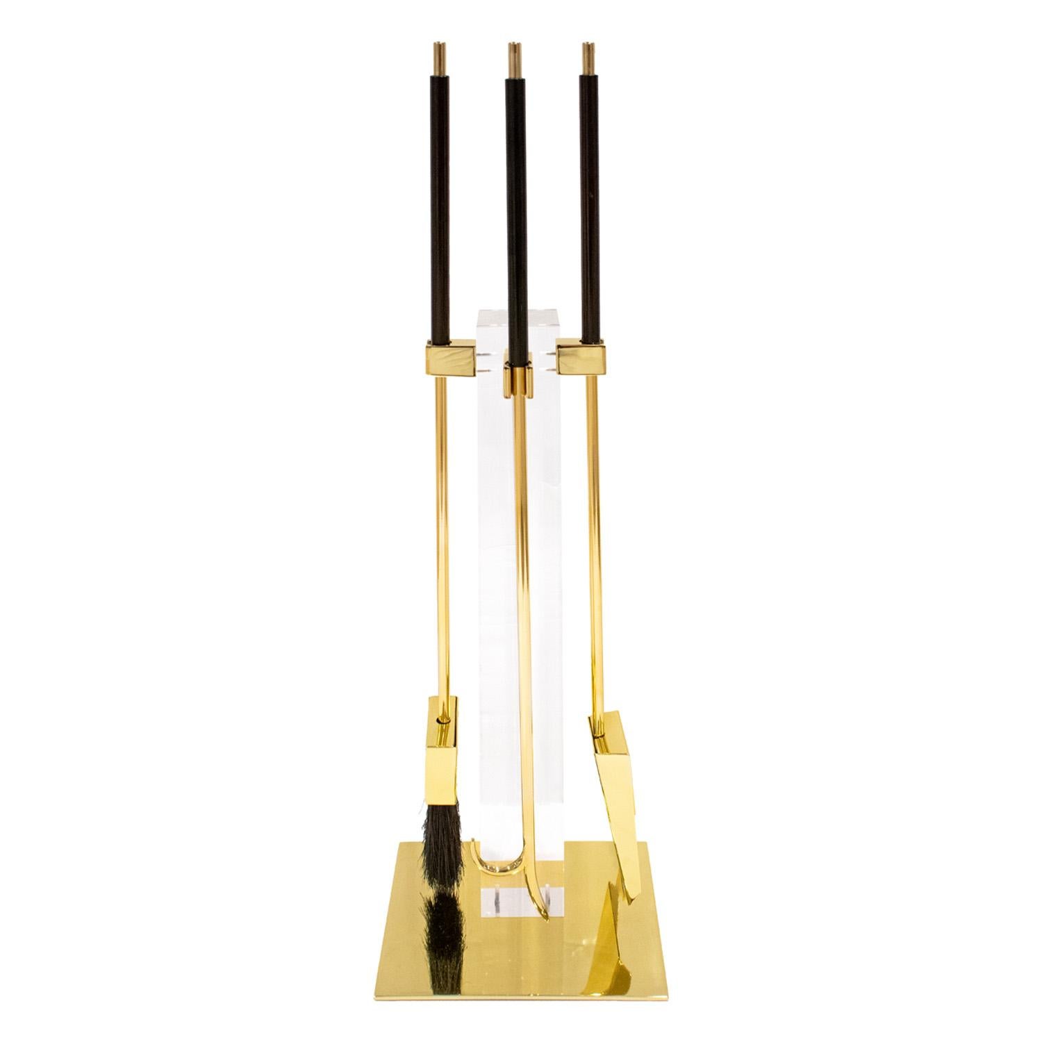 Fireplace tool set with upright post in lucite and tools in brass with black resin handles by Danny Alessandro LTD, American 1980's.  This iconic tool set is both useful and very chic. Danny Alessandro, Ltd. was sold through Holly Hunt in the
