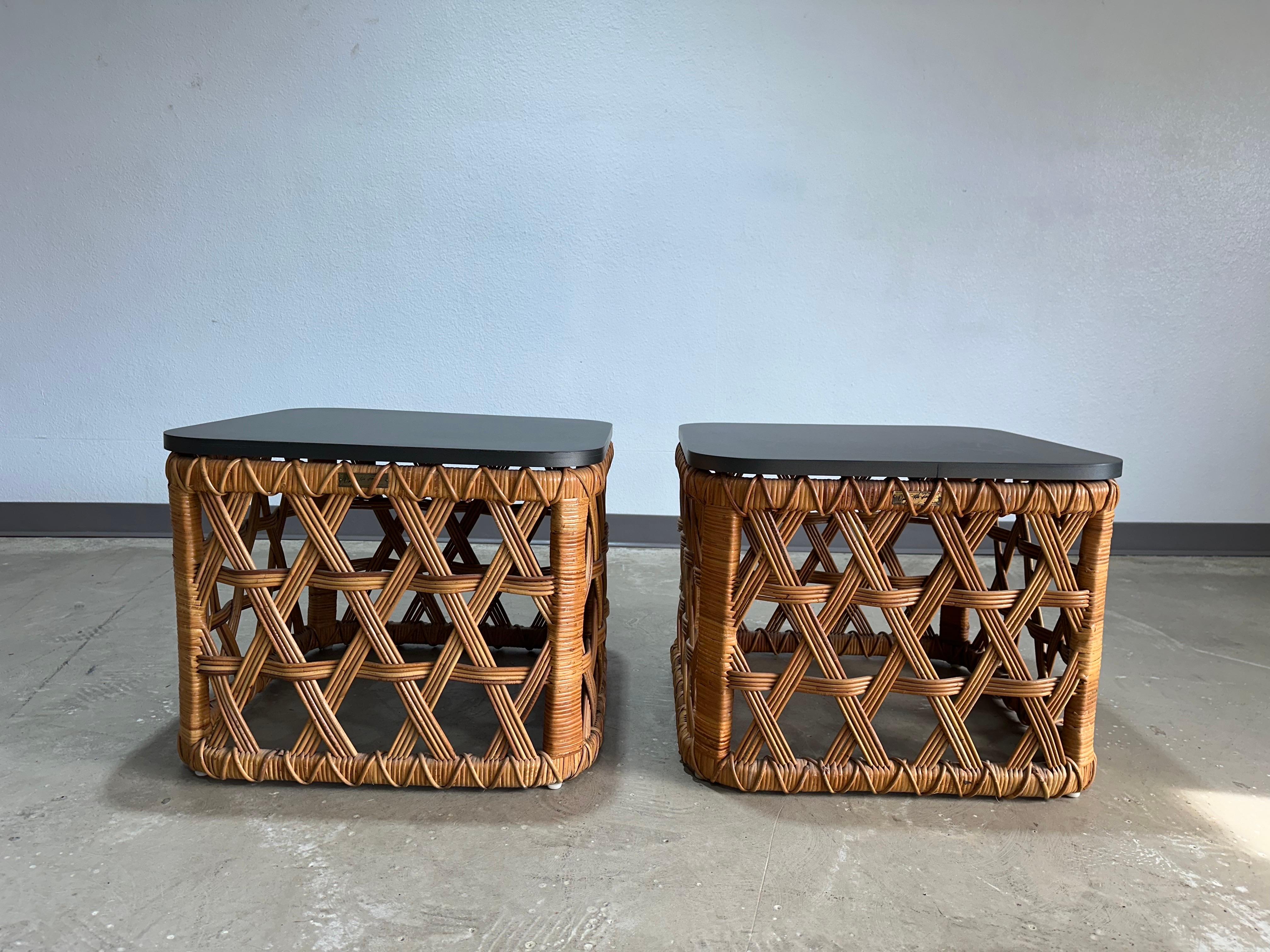 Pareja de mesas auxiliares/extremas de ratán tejido en cesta modelo Tanganika, poco comunes, diseñadas por Danny Ho Fong para Tropi-Cal hacia la década de 1970. Preciosos bastidores abiertos de ratán tejido a mano con tapas compuestas de color