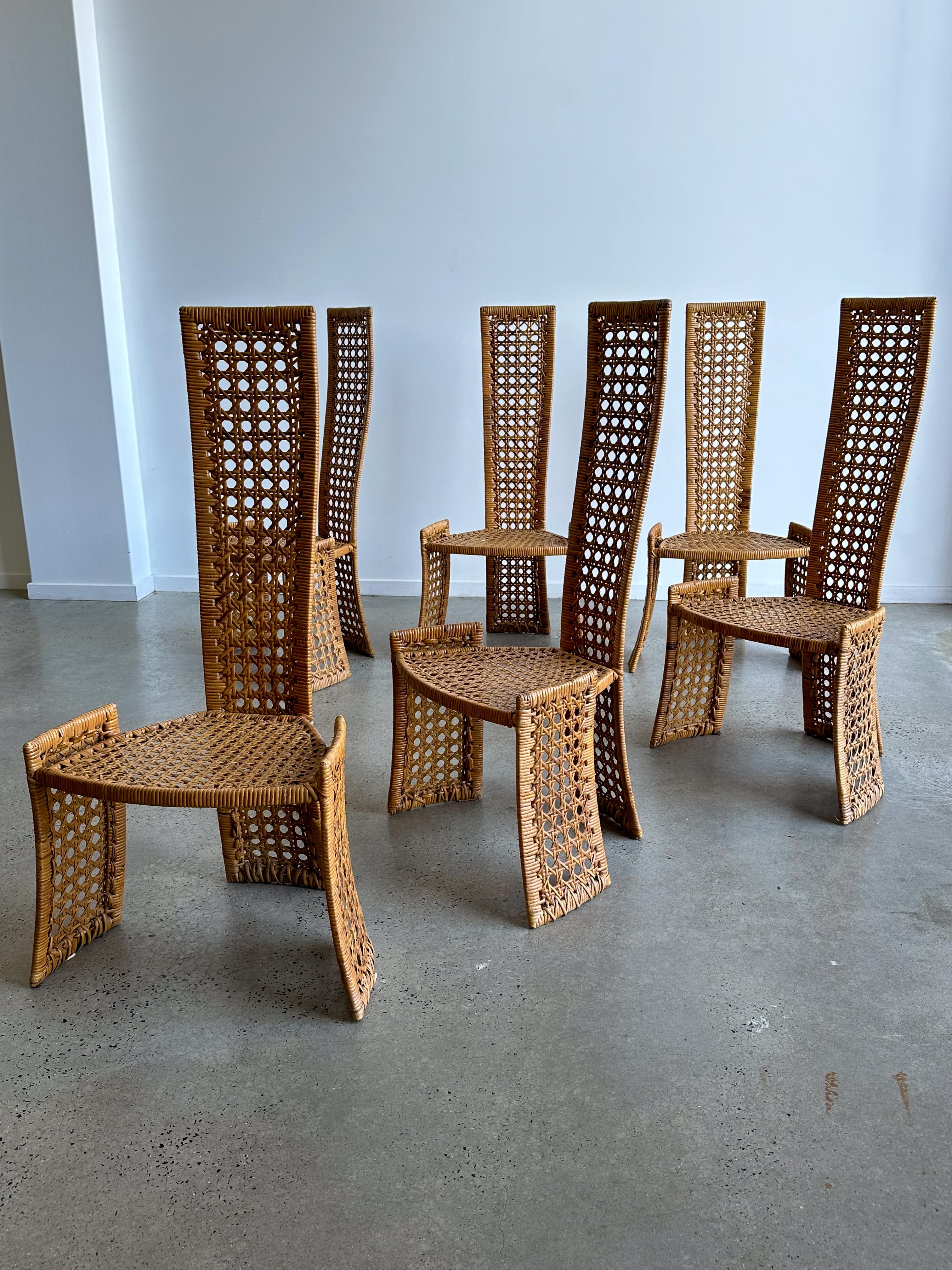 A fabulous unique set of six rattan dining chairs from a difficult to find series by the wildly creative Danny Ho Fong for Tropi-cal, circa 1975. Beautiful rattan over steel frame construction. The high-back design gives a clear wink to the