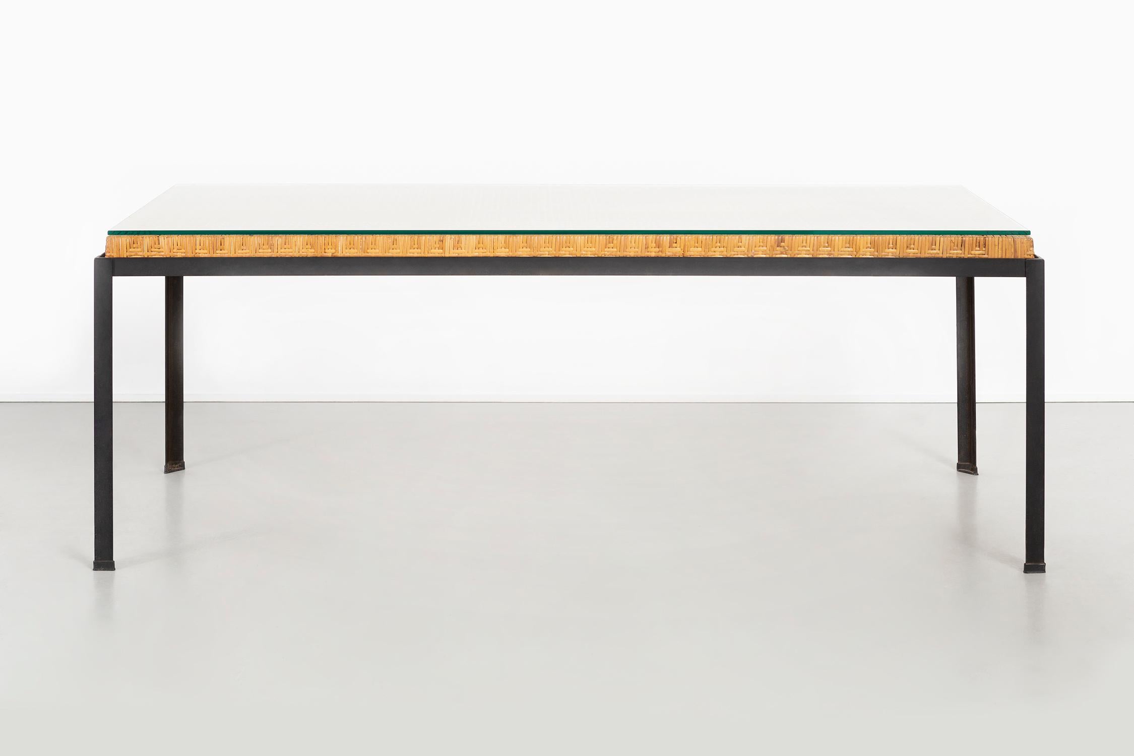 Designed by Danny Ho Fong for Tropi-cal 

USA, circa 1960s

Glass and iron and handwoven reed 

Measures: 25 ?” H x 73 ½” W x 30 ¾” D.

Great patina with a new glass top

This table is suitable as an intimate dining table, desk or console