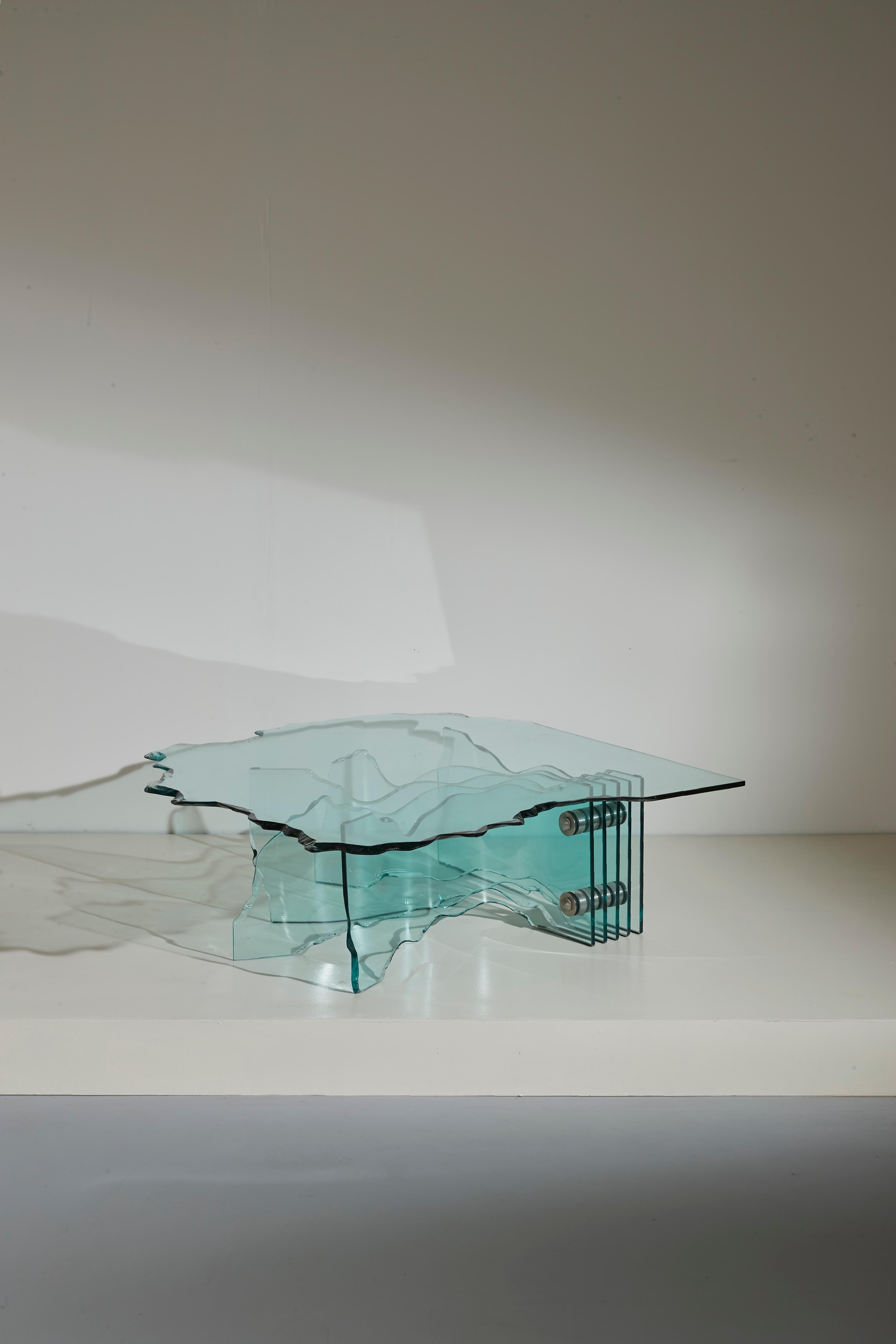 A beautiful 'Shell' Coffee table, produced for the first time in the 1989 by FIAM (Tavullia, Italy) and designed by the iconic artist Danny Lane. 

Made of partially curved, chiselled and hand polished clear glass, it can create a great atmosphere