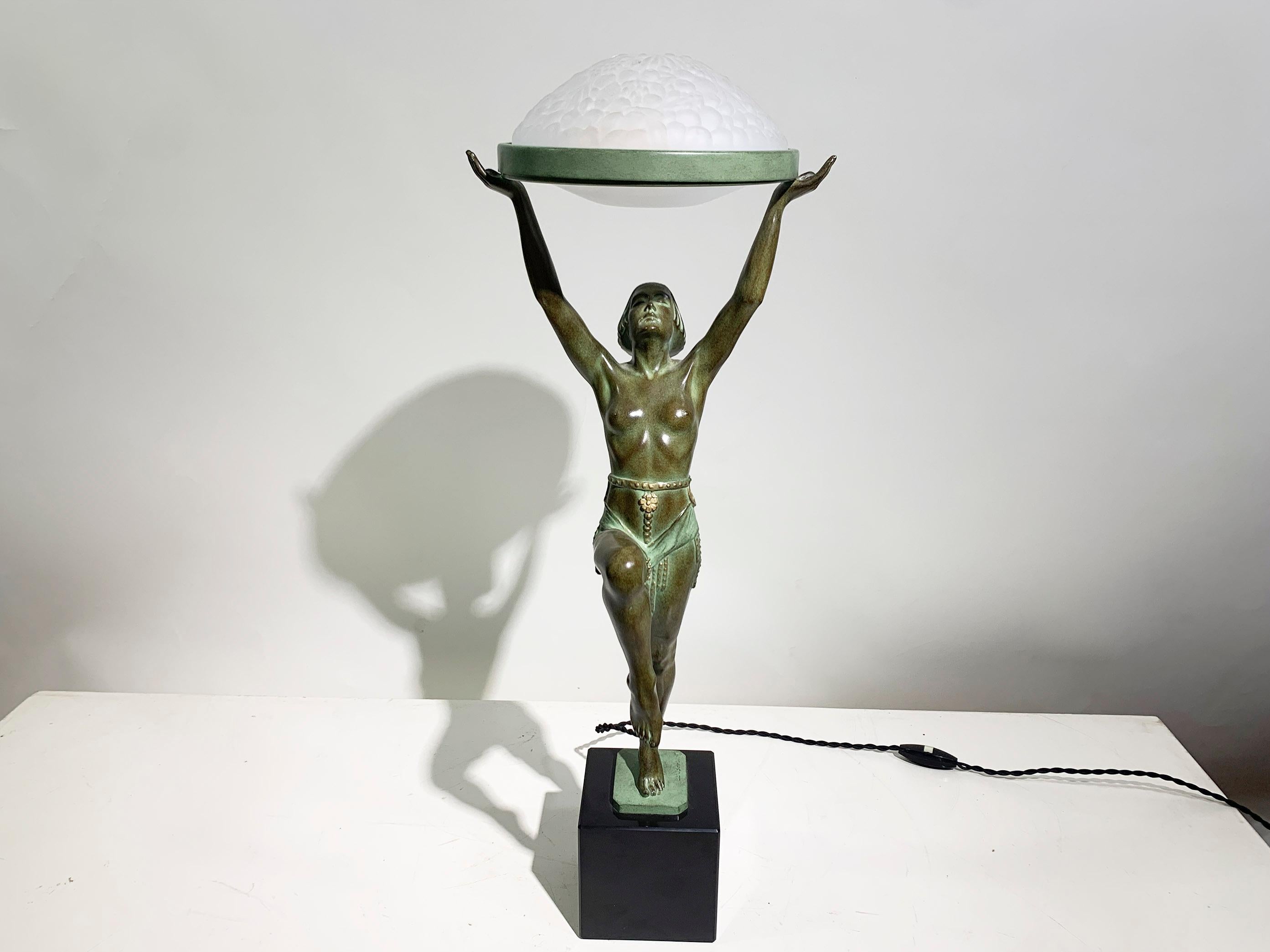 Elegant Art Deco-style figural table lamp featuring a graceful lady holding a glass shade. Designed circa 1930, this contemporary posthumous cast bears the signature and Le Verrier foundry mark. Crafted in patinated art metal with a black marble