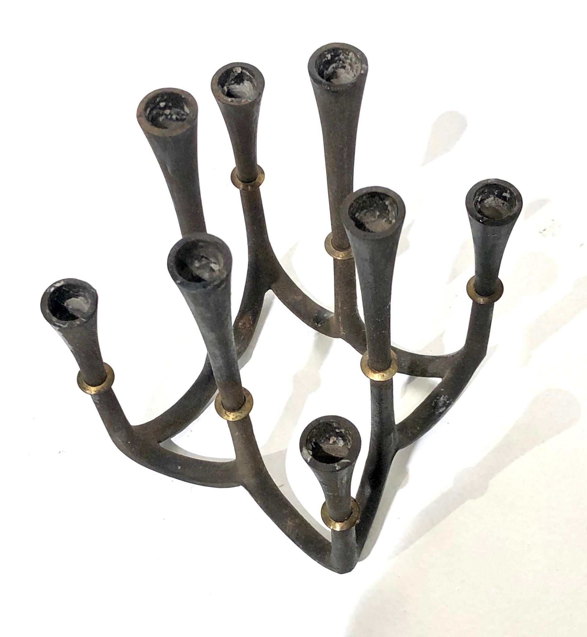 This 1950s cast iron and brass candleholder was designed by Jens Quistgaard. It holds 8 taper candles .5