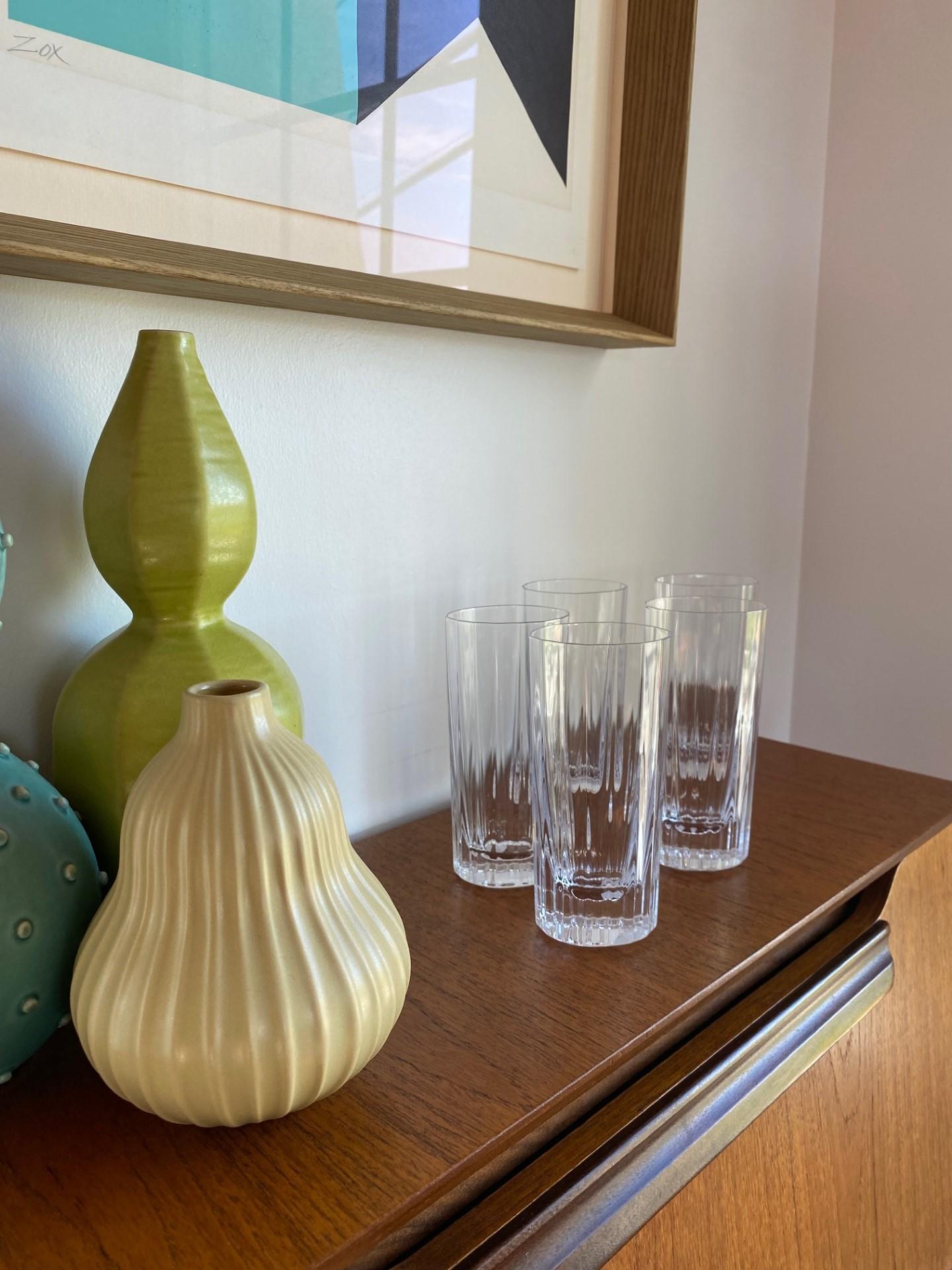 Tall, column like, crystal clear and modernist in essence, these beautiful glasses will make a statement in your bar.  Each highball glass is 6” tall and 2.75” wide.  All together, these glasses project a spark like glow with their minimalist lines.