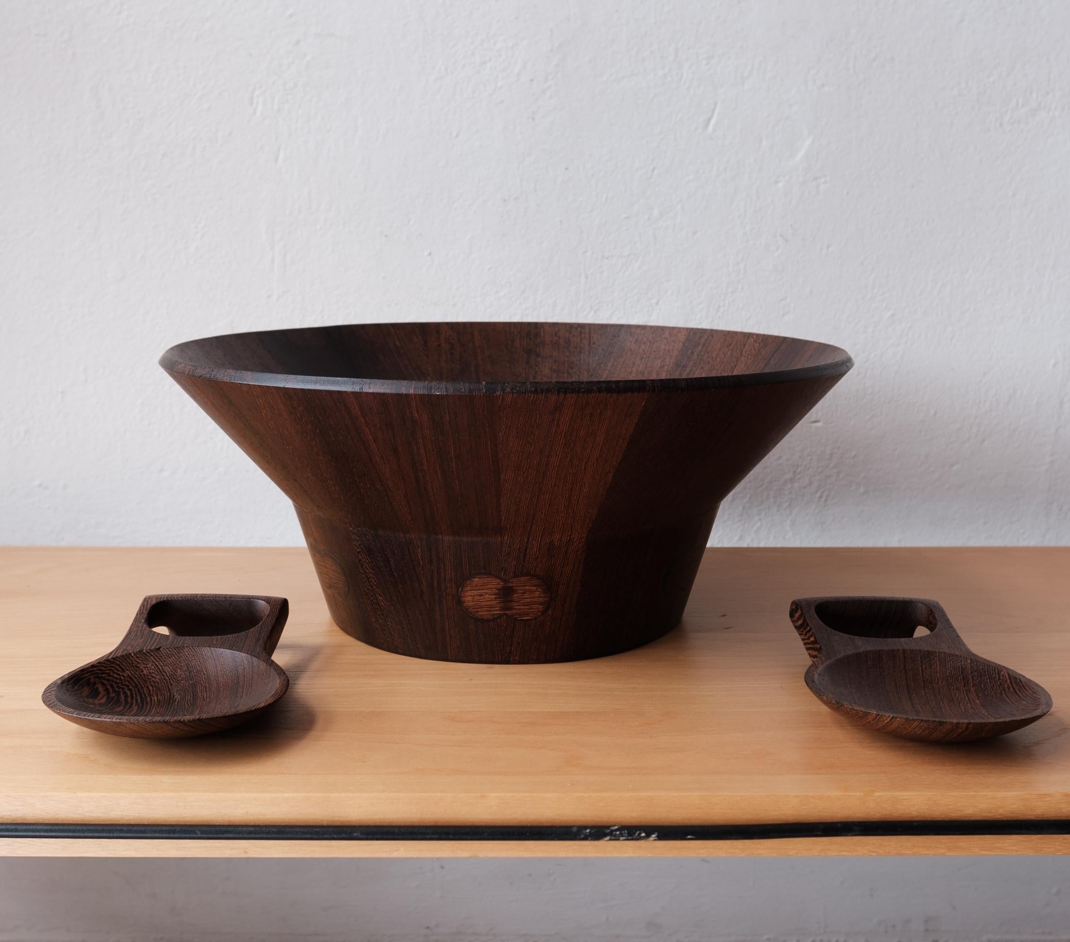 Large and rare salad bowl and tongs designed by Jens Quistgaard for the Dansk rare woods line. Introduced in 1961, the Rare Woods line was the finest designs and materials. 

Dansk described them:
Good design grows out of its materials, no matter