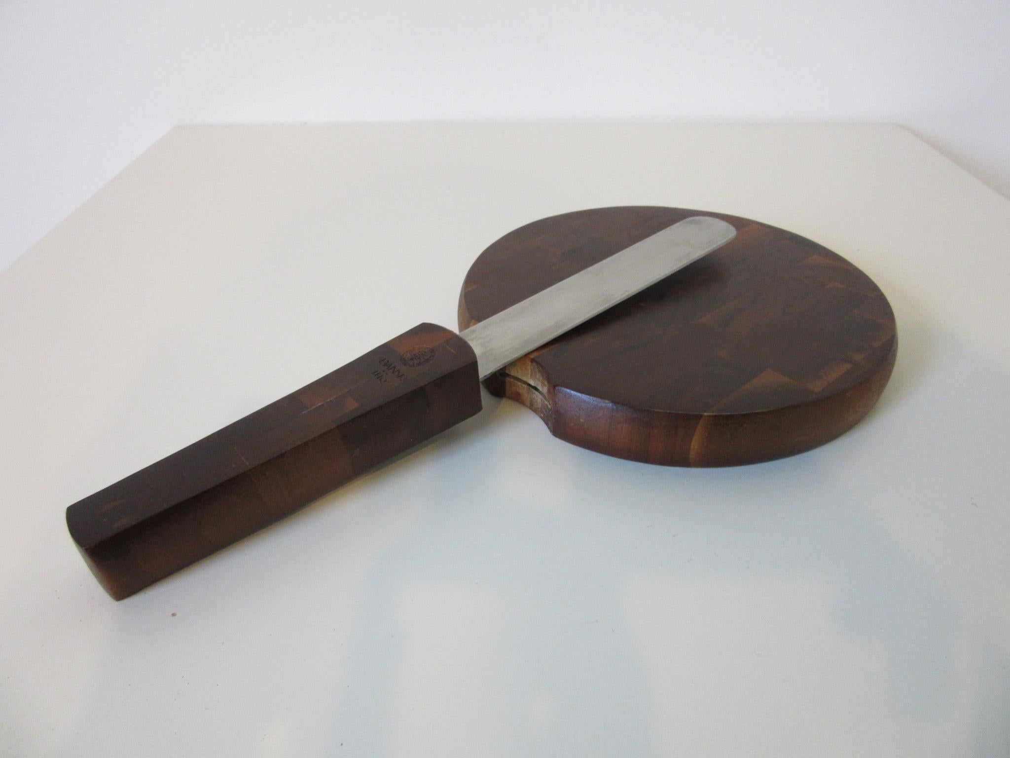 A beautifully designed mosaic rosewood cheese board with integrated stainless steel sharp edge knife as the handle . An early production piece with the four ducks mark and JHQ with Dansk trademark to the knife handle, made in Denmark. The knife