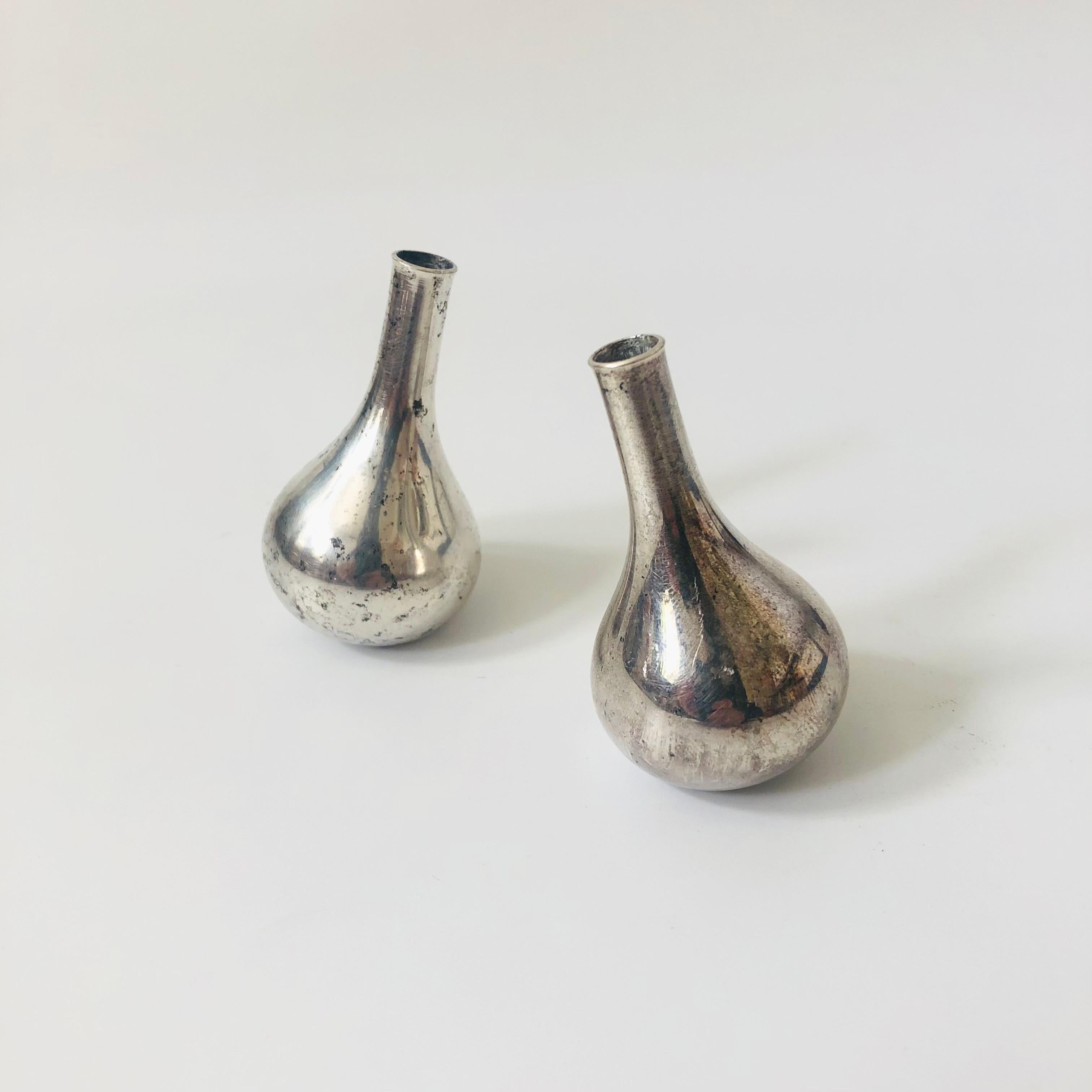 A pair of mid century silver plated tiny taper candle holders. Onion shaped with faceted bases so that the candle holders can either stand upright or tilted. Made in Denmark by Dansk and designed by Jens Quistgaard, each pieces is marked on the