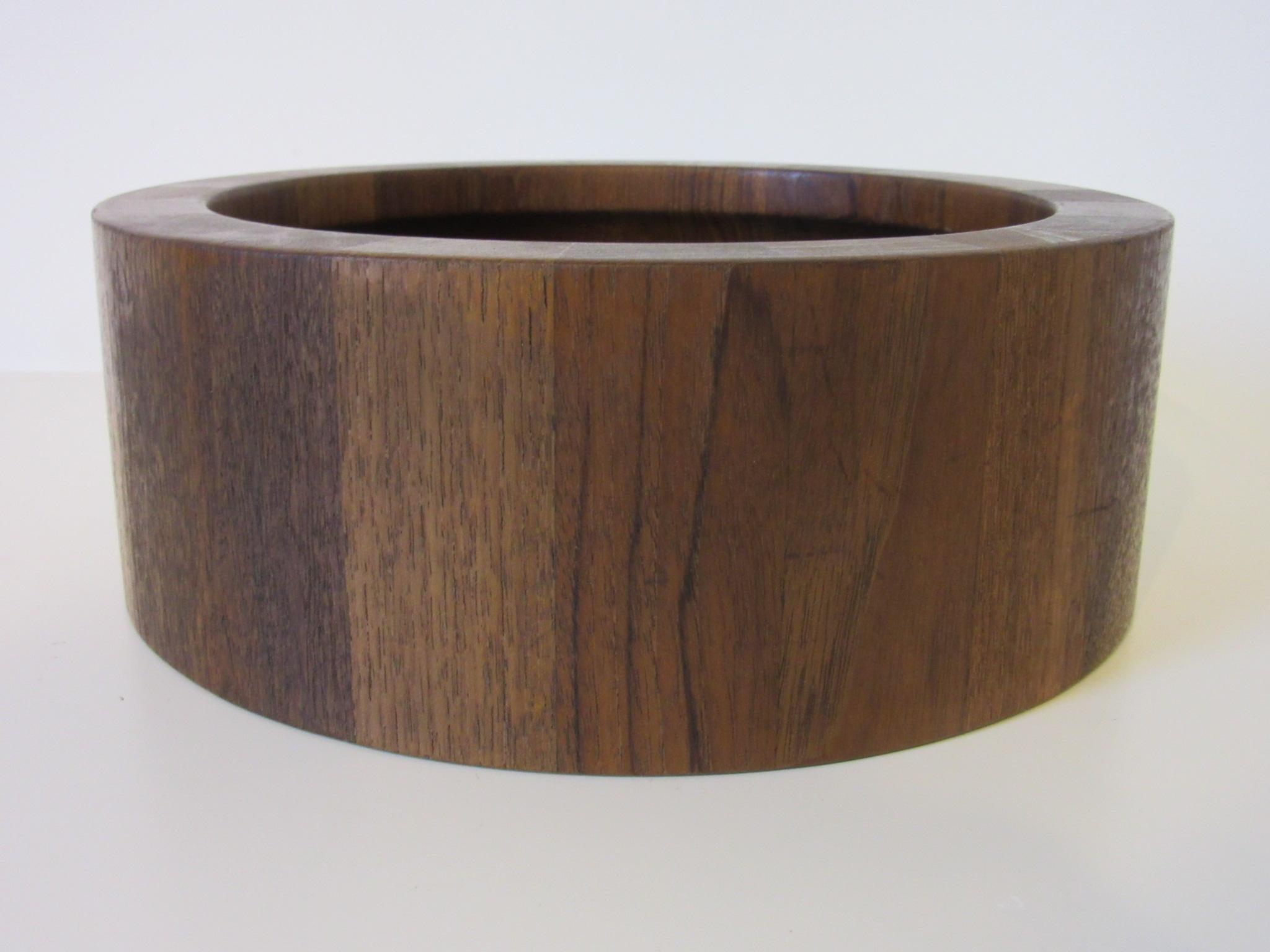 A teak wood bowl by famed Danish designer Jens Quistgaard with staved designs of dark and lighter grained wood, branded mark to the base IHQ / Denmark Dansk .