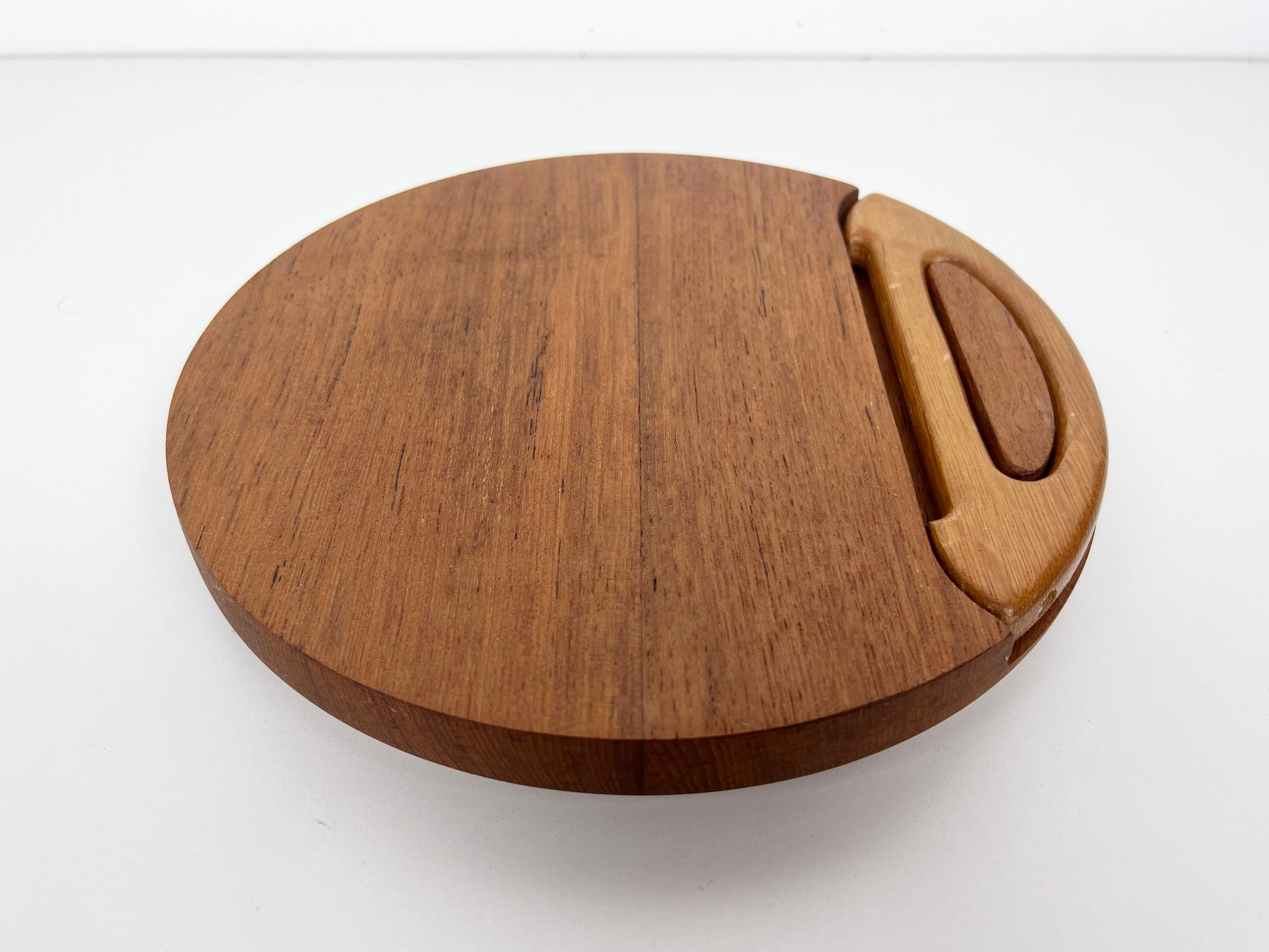 Vintage cheese board crafted from solid teak with built-in wire cheese knife. Features the Dansk four ducks logo on bottom. 

Designer: Jens Quistgaard

Manufacturer: Dansk

Dimensions: 1.3
