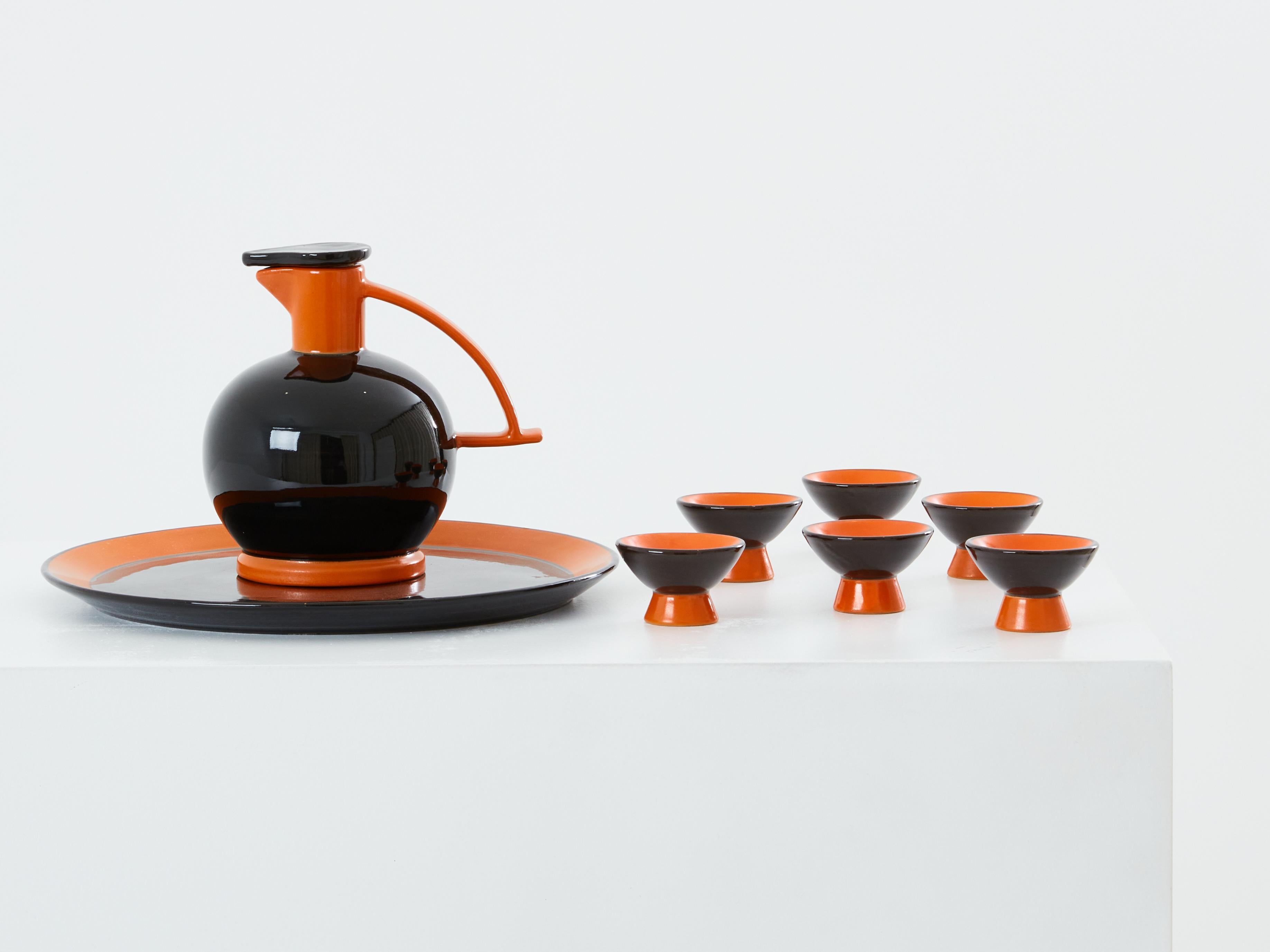 This liqueur set was designed by Dante Baldelli for the renowned Italian ceramicist Rometti Umbertide in 1930. It consists of a liqueur decanter, six matching glasses, and a round tray. Each piece of this glazed ceramic set features distinctive