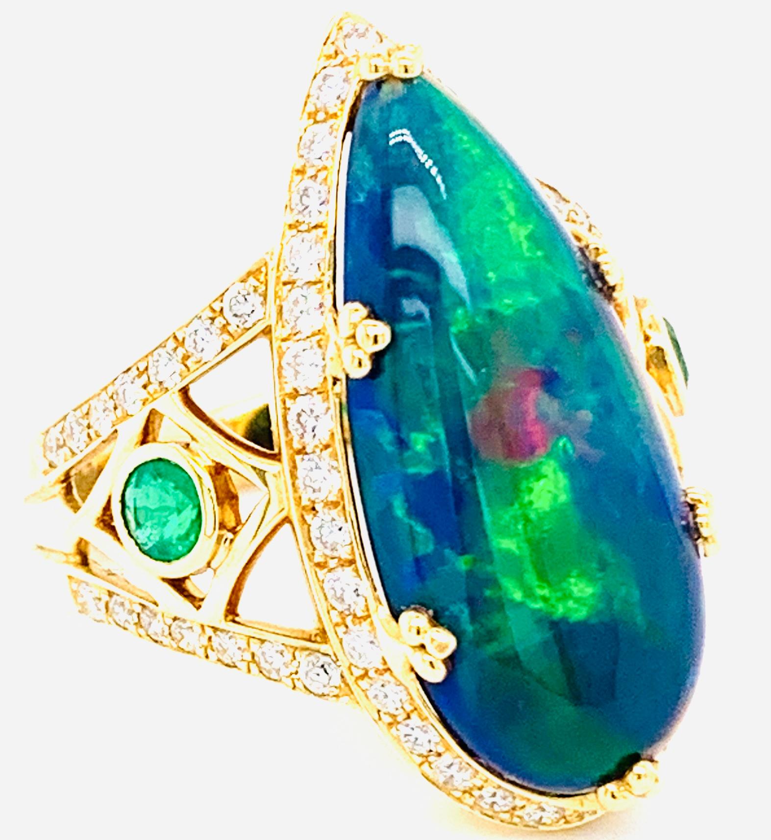 Danuta Striking schimmernden Farben der tiefen Wald und blauen Ozean äthiopischen Birne geformt Opal Verlobungsring . Der Opal in der Mitte hat 6,42 Karat, umgeben von eingefassten Diamanten von 0,70 Karat. Die Seiten haben 2 Smaragde .23 Karat
