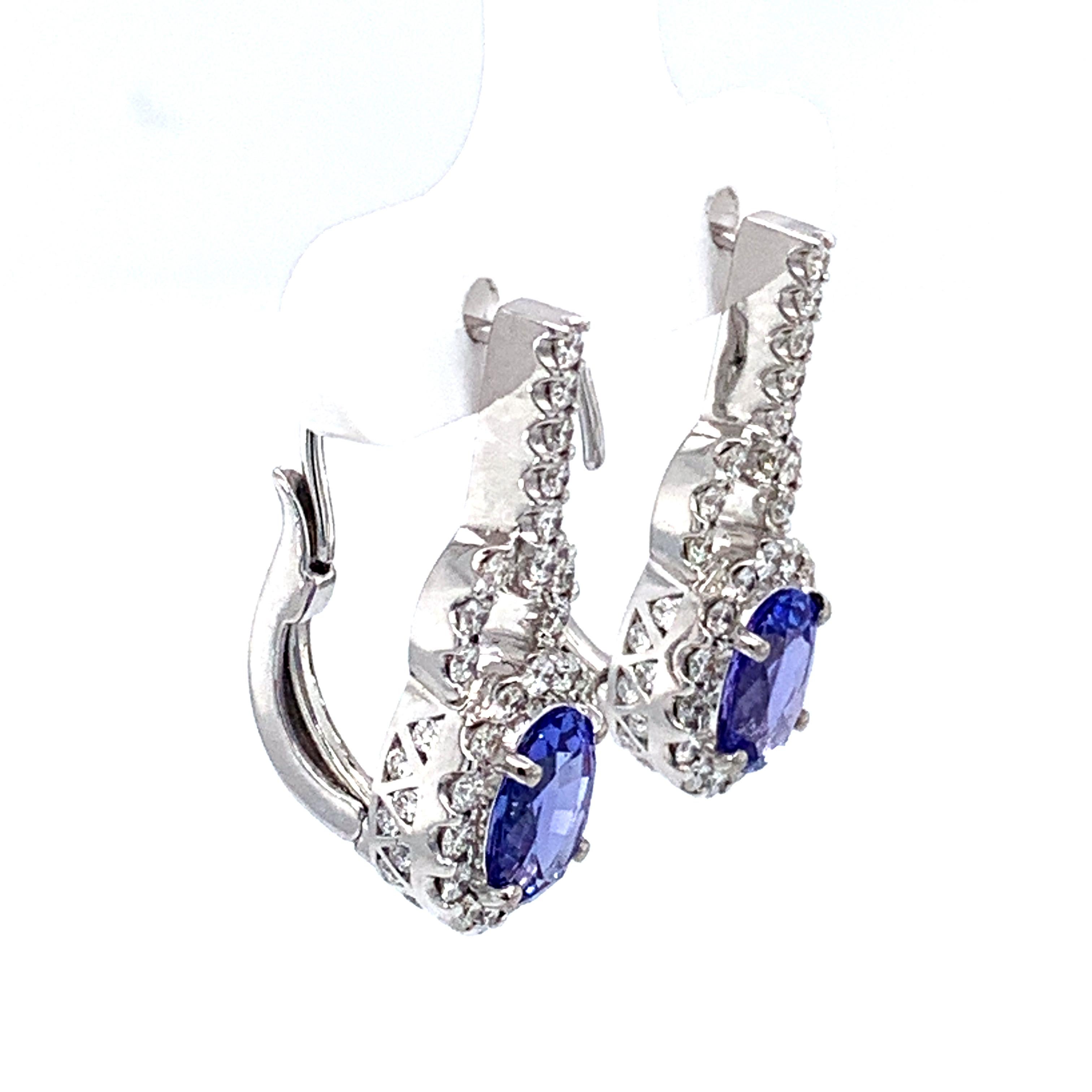 Stunning 1.47 carat weight oval tanzanite hanging earrings surrounded by white diamonds 1.36 carat in weight FG color VS1 clarity.
