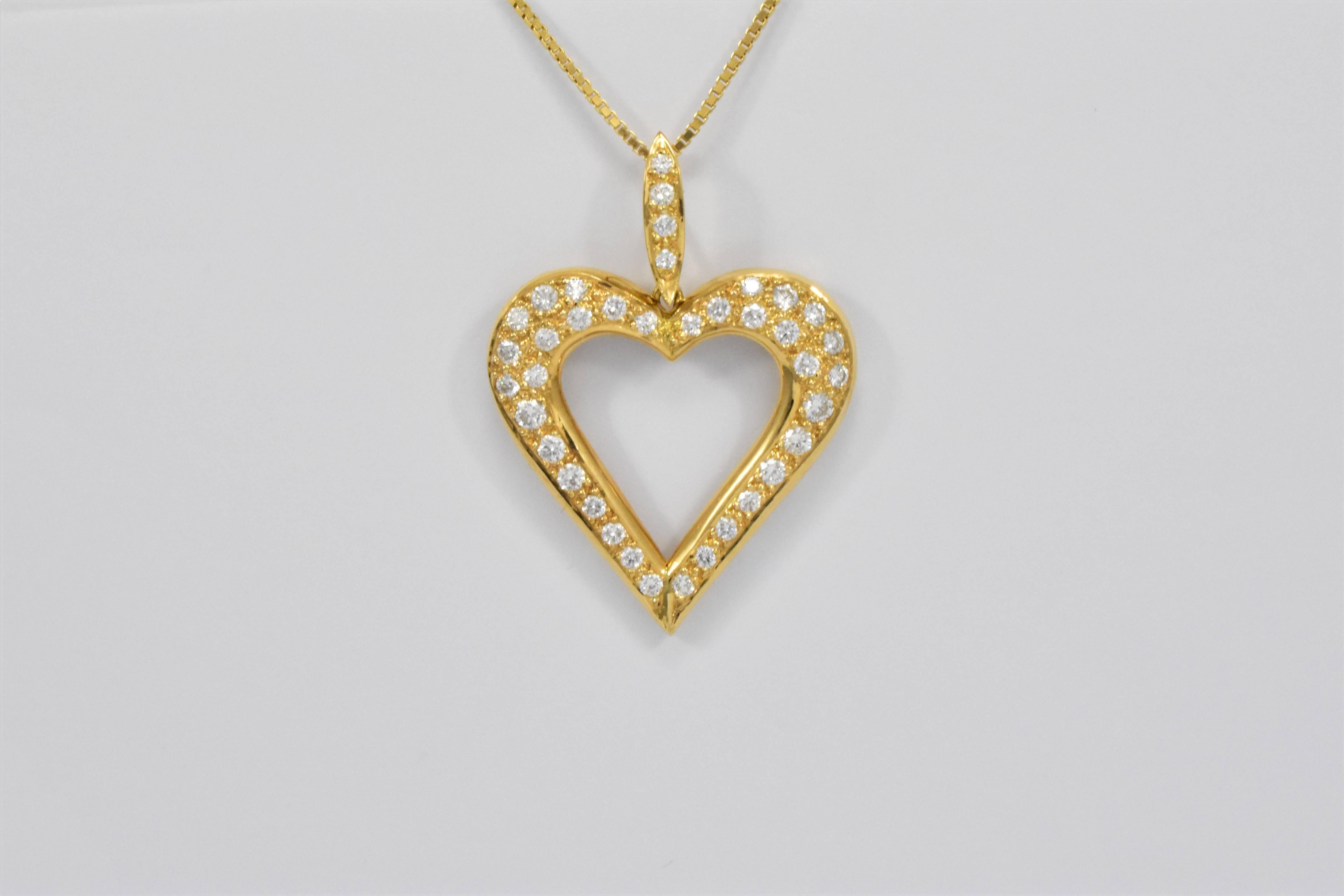 A striking bright large gold heart pendant beautifully proportioned with a diamond set sculptural hinged bail chain loop. The Open Heart has a gently curved rounded surface set with pavé round brilliant cut diamonds in 18 karat yellow gold and comes