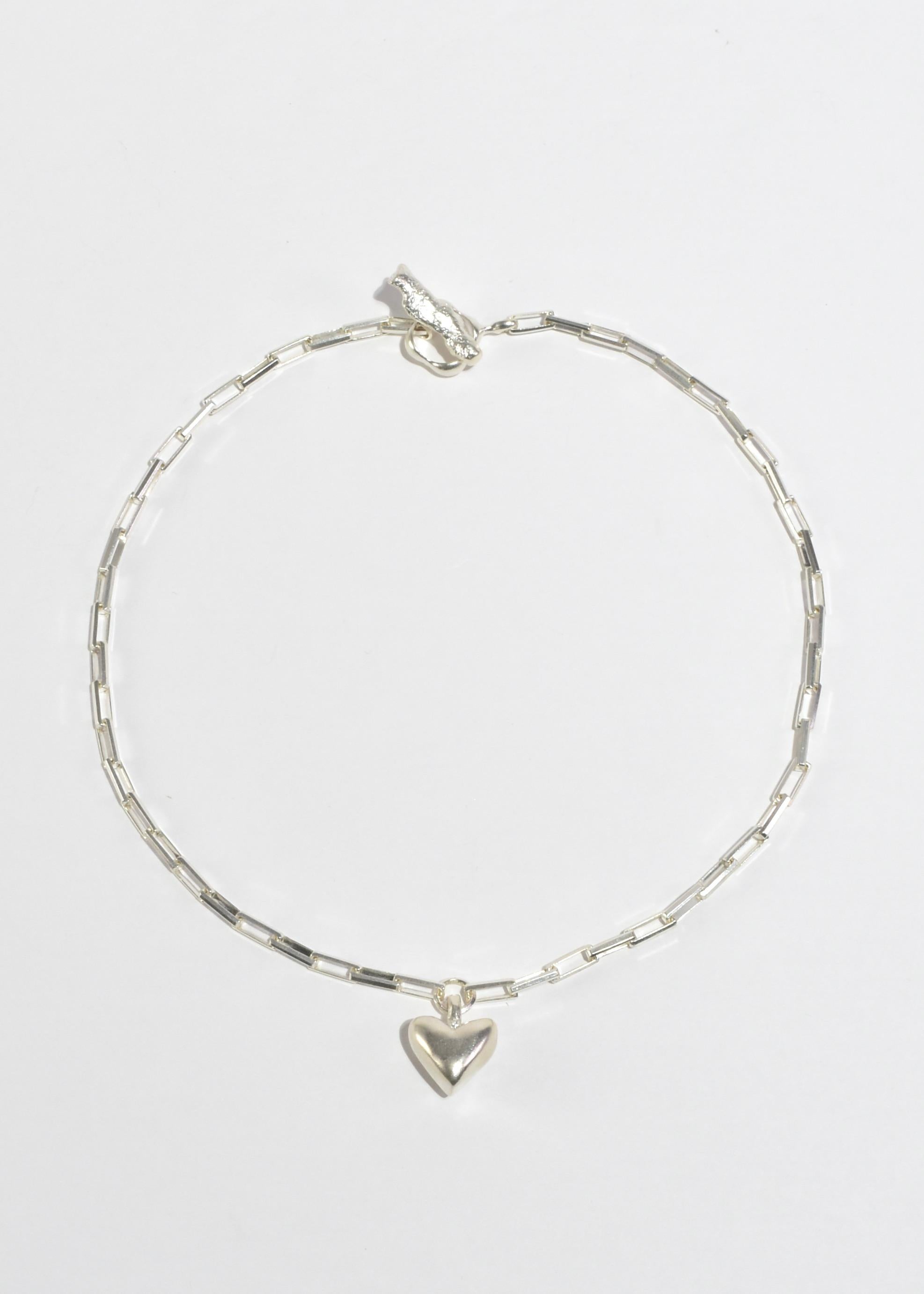 
La collana Daphne presenta la caratteristica chiusura Dunton Ellerkamp, maglie di catena rettangolari e un ciondolo a cuore. Assemblato in argento massiccio con una catena in argento italiano.

Ogni pezzo è scolpito, fuso e rifinito a mano a New