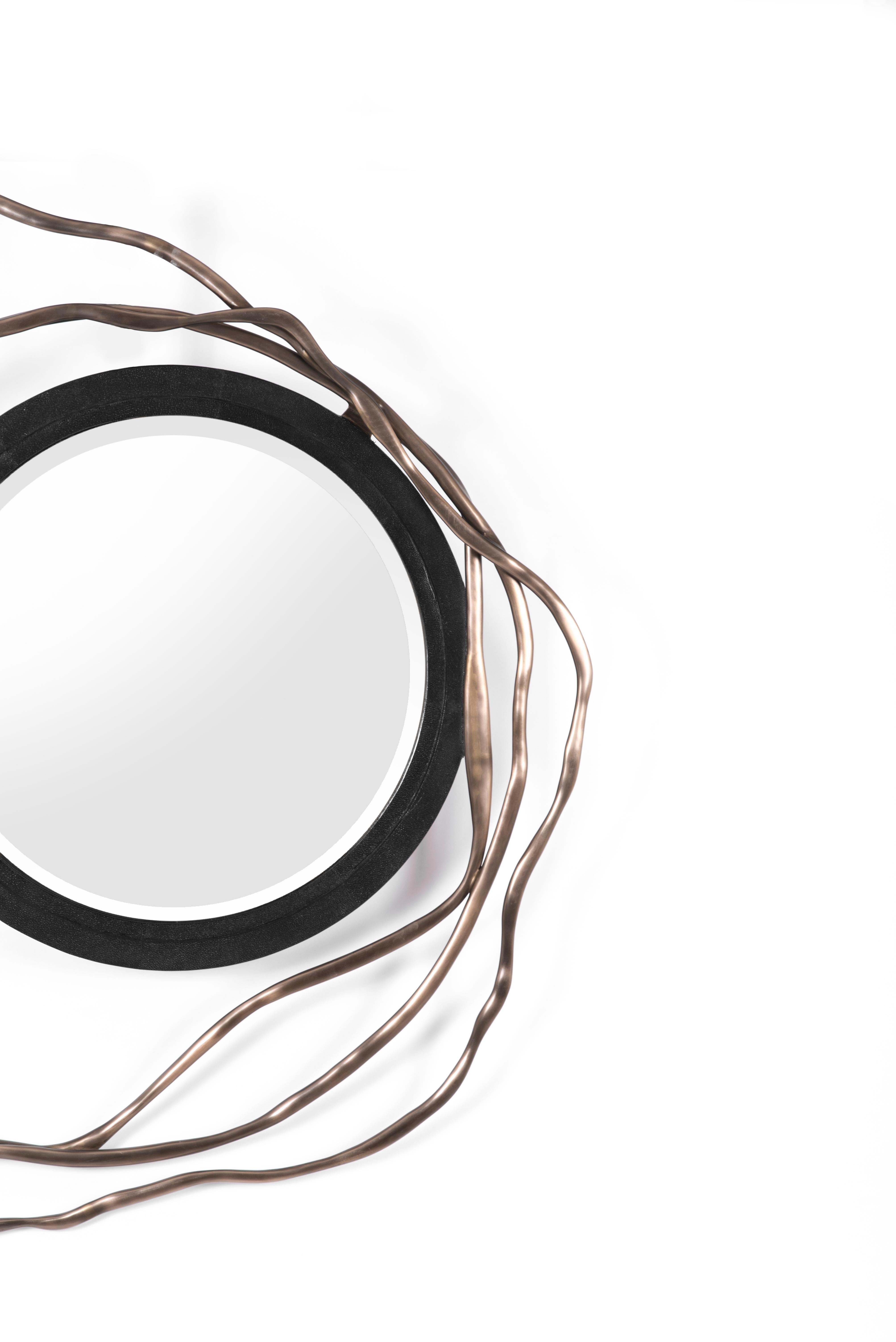 Der Dargelos-Spiegel ist mit seinen ätherisch inspirierten Wurzeln ein Statement. Die Verflechtung der gedrehten Bronze-Patina-Messingdrähte mit dem kreisförmigen schwarzen Chagrin-Rahmen des Spiegels schafft ein wahrhaft skurriles Gefühl, wobei das