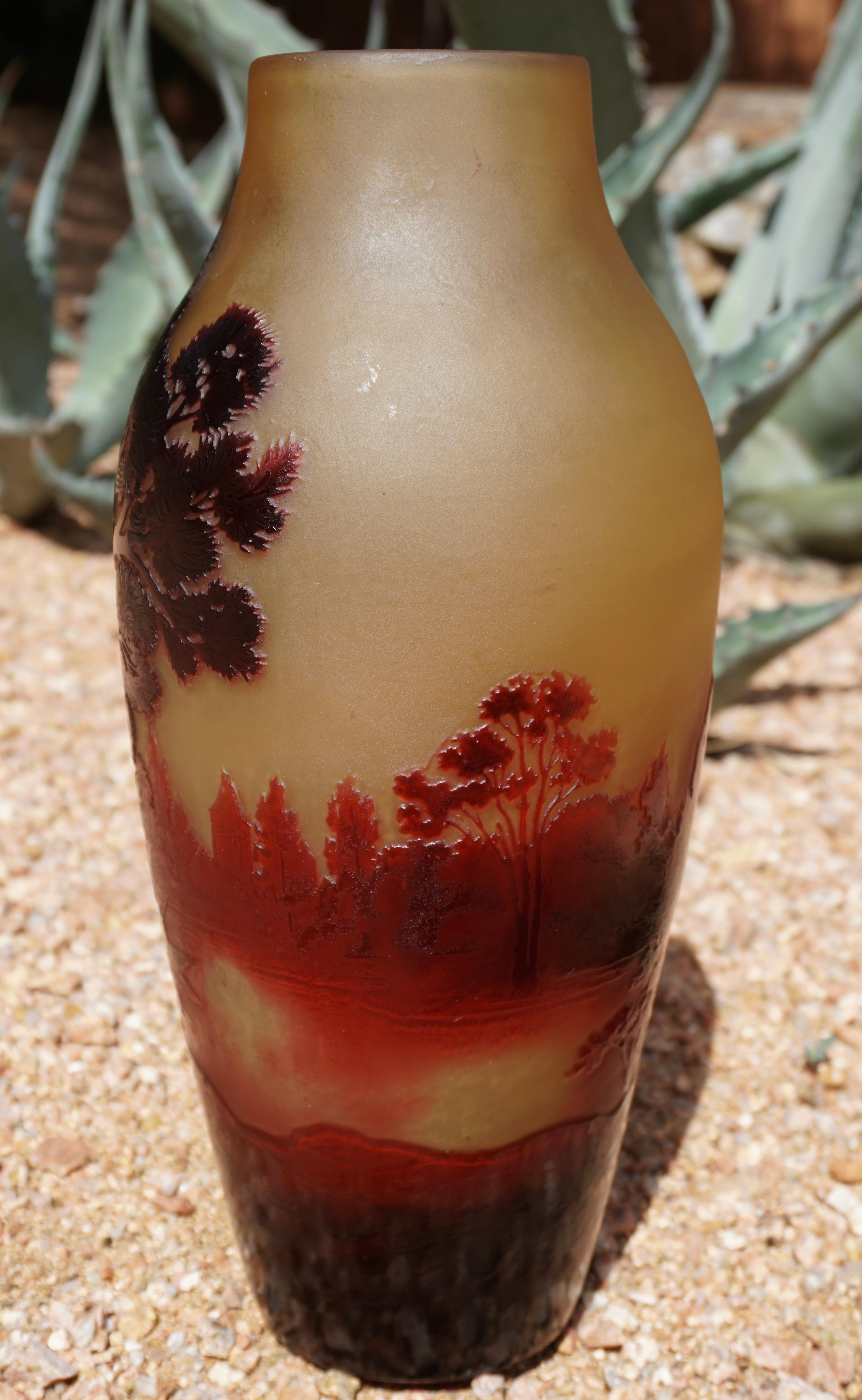 A monumental acid etched cameo Art Nouveau red and yellow art glass scenic vase depicting a fisherman in a boat on a lake of red with trees in the foreground. This vase is for serious collectors and will be sure to please. Perfect delectable size at