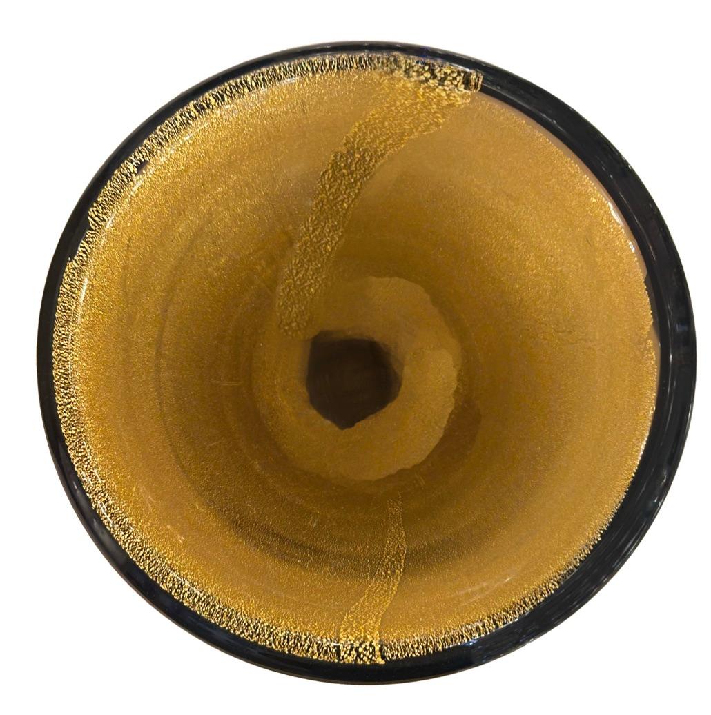 Realizzata a mano dagli abili artigiani di Murano, questa ciotola in vetro mostra i colori vivaci e i dettagli intricati che caratterizzano la tradizione vetraria dell'isola. Di uno squisito colore ambrato scuro con il centro in avventurina dorata,