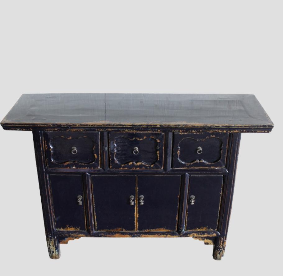 This antique altar table was restored to current dark blue color. It’s solid elm with three drawers and four doors, and has a nicely carved scrollwork border repeated through the decorative hardware and carved footings. It can be used as a