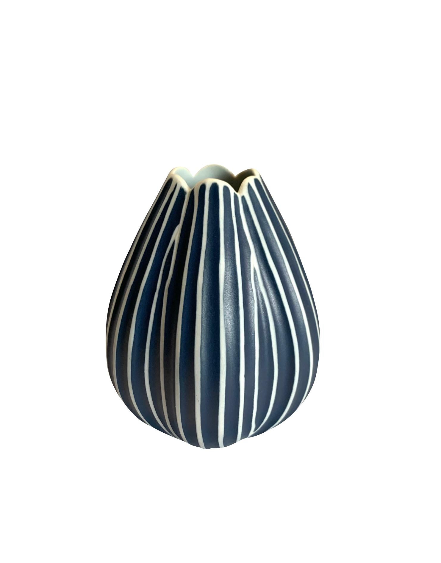 Contemporary Thailand dark blue and white vertical stripe vase.
Lotus design shape
Can hold water
Part of a collection of unusually shaped blue and white vases.
See image #5.