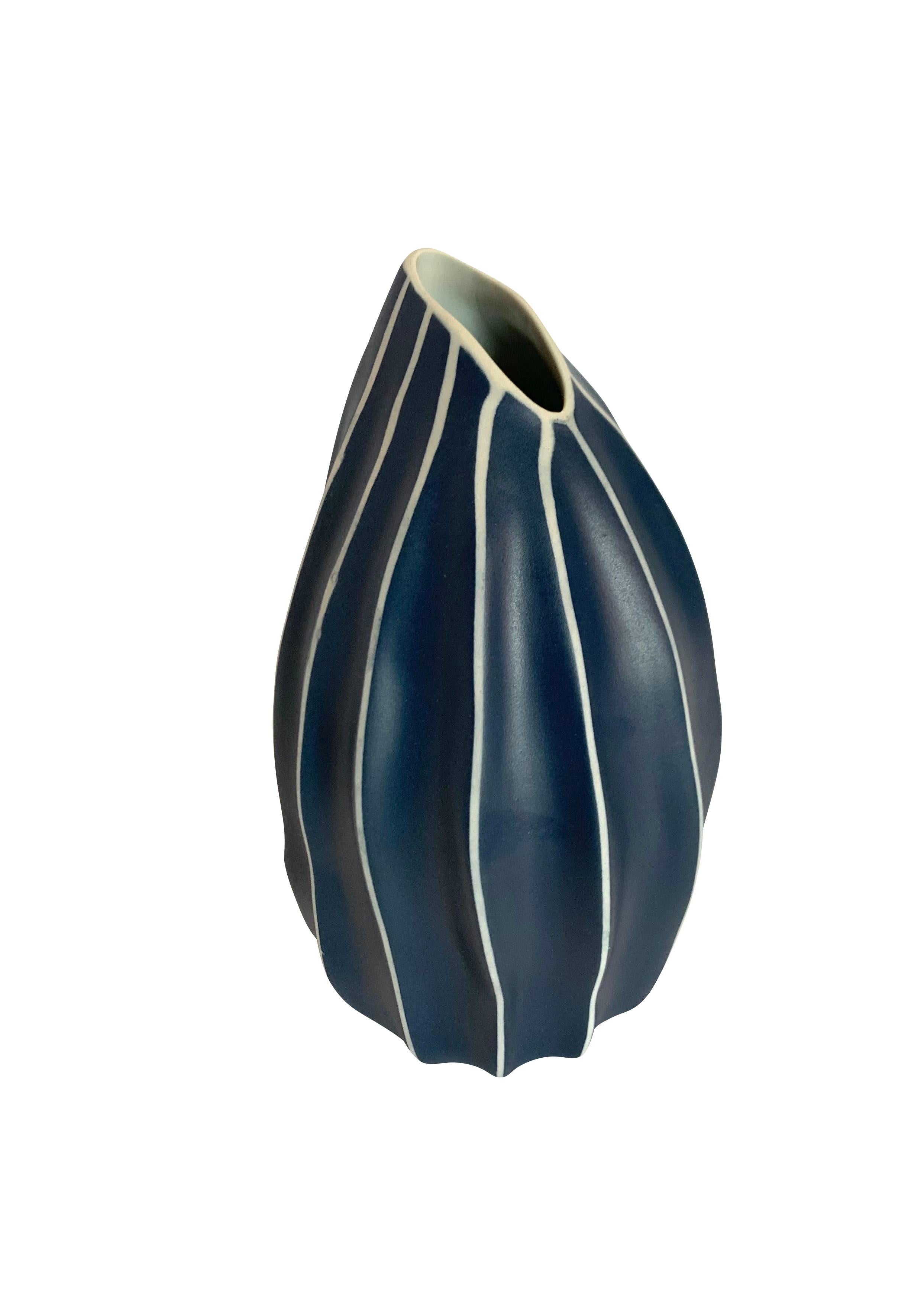 Contemporary Thailand dark blue and white vertical stripe vase.
Slanted oval opening.
Can hold water.
Part of a collection of unusually shaped blue and white vases.
See image #5.