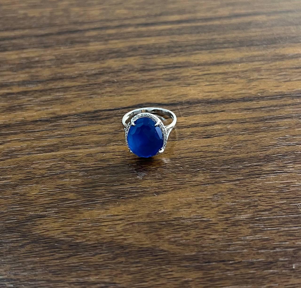 A striking ring featuring a captivating blue azurite.

Set in 14k gold, this exquisite piece showcases a large, faceted blue azurite, elegantly framed by a halo of sparkling diamonds.

The deep blue gemstone is the centerpiece, its rich color