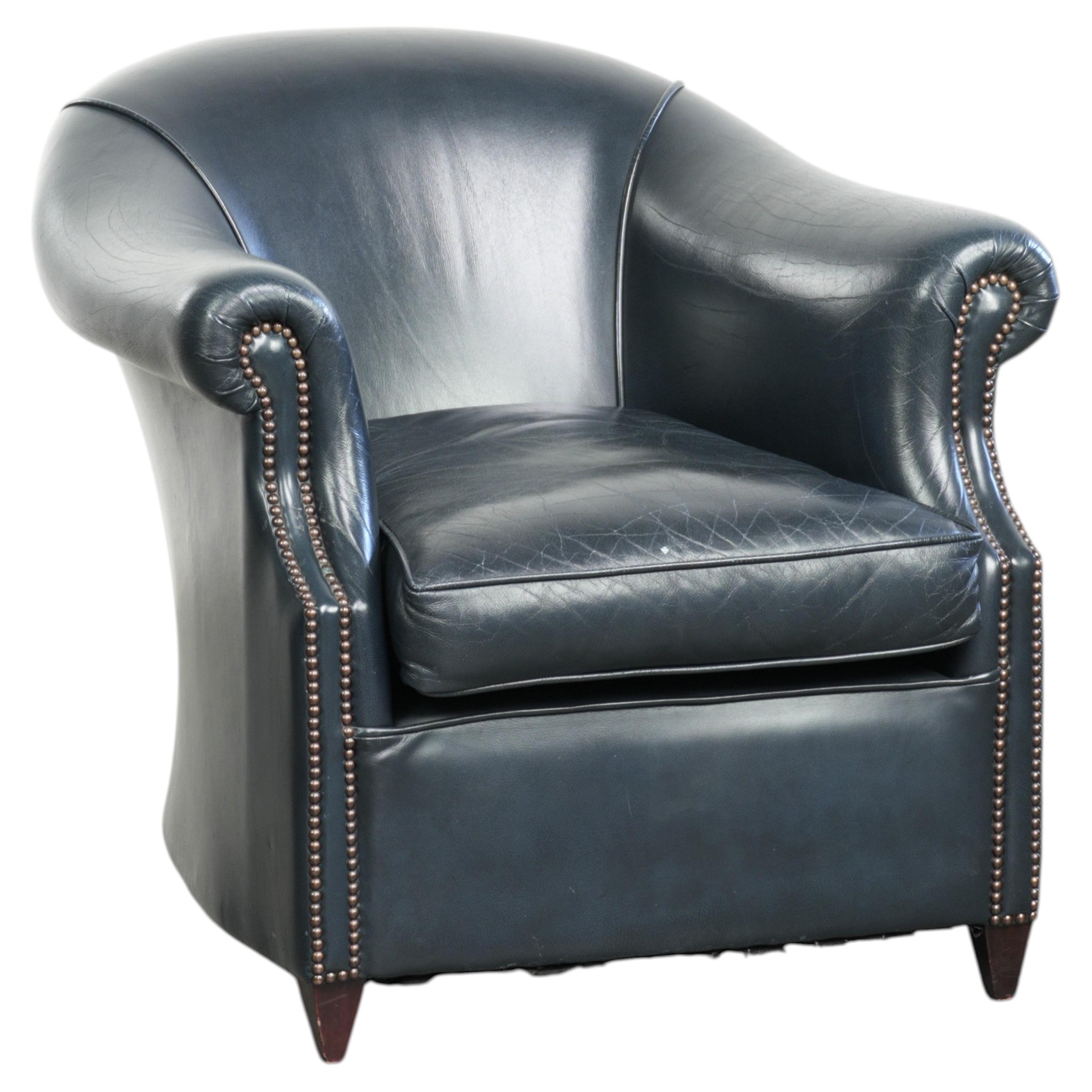 Fauteuil club bleu foncé en cuir de vachette au design intemporel.