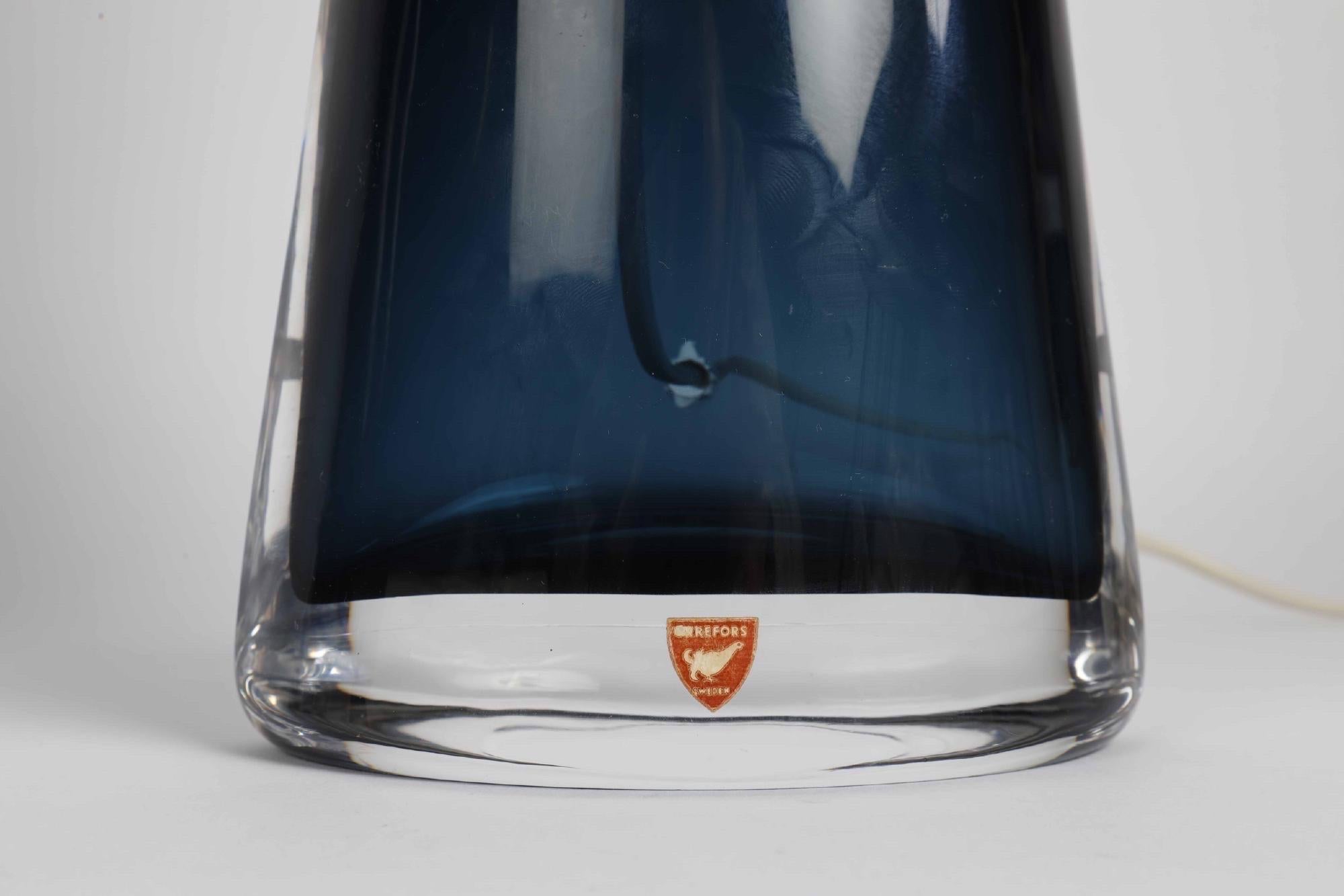 Grande paire de lampes en verre bleu foncé Orrefors avec des accessoires chromés, signées Carl Fagerlund Orrefors.
Le corps en verre mesure 12