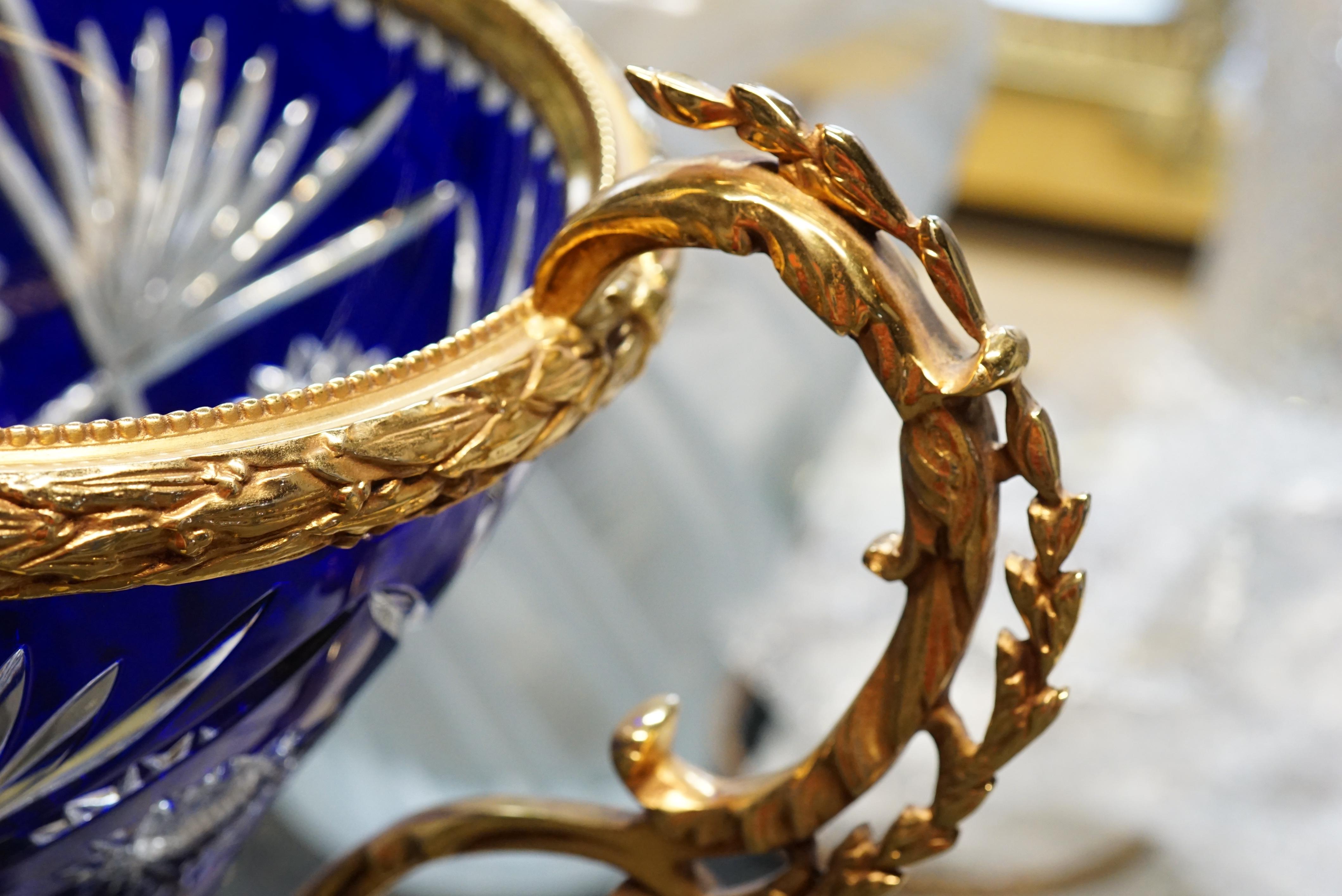 Dark blue crystal vase with covered gold bronze.

Measurements: H 135 cm x D 27 cm

Majestuous dark blue crystal vase embellished with gold covered bronze. 
Last piece of an old collection, in good condition.
The crystal and blown mouth and