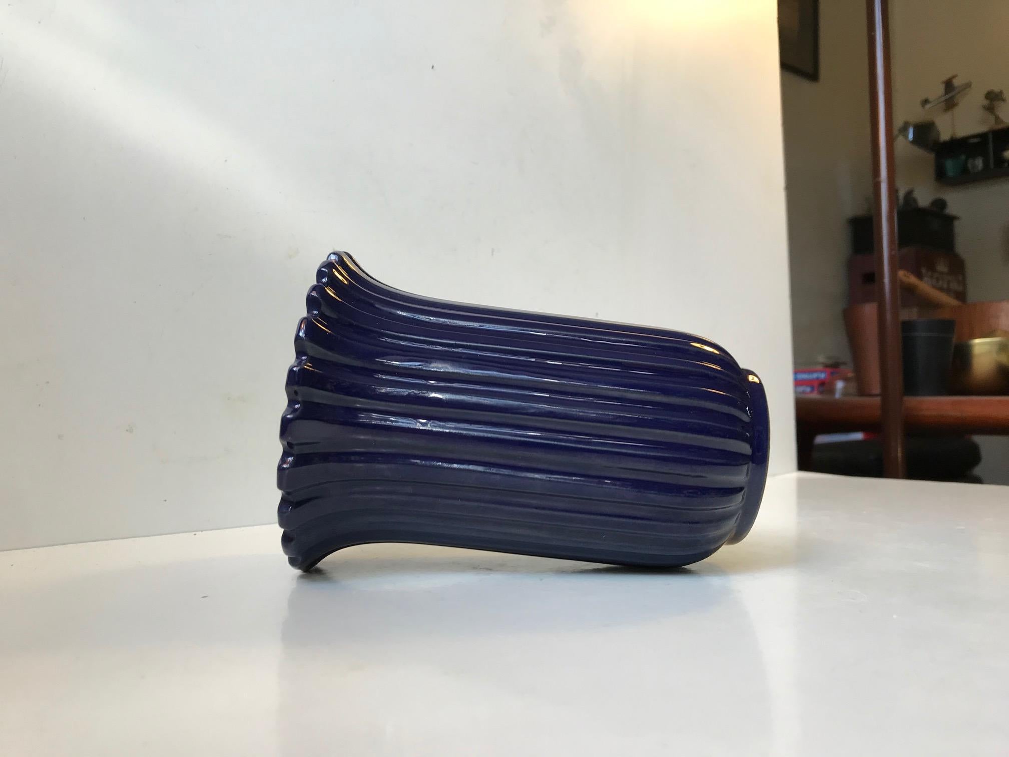 Art deco revival ceramic vase from the 1970s. Fluted fully glazed corpus in dark blue. This color is by far the rarest. Its designed by Eslau in Denmark and manufactured at their own Studio during the 1970s. This style has clear reference points to