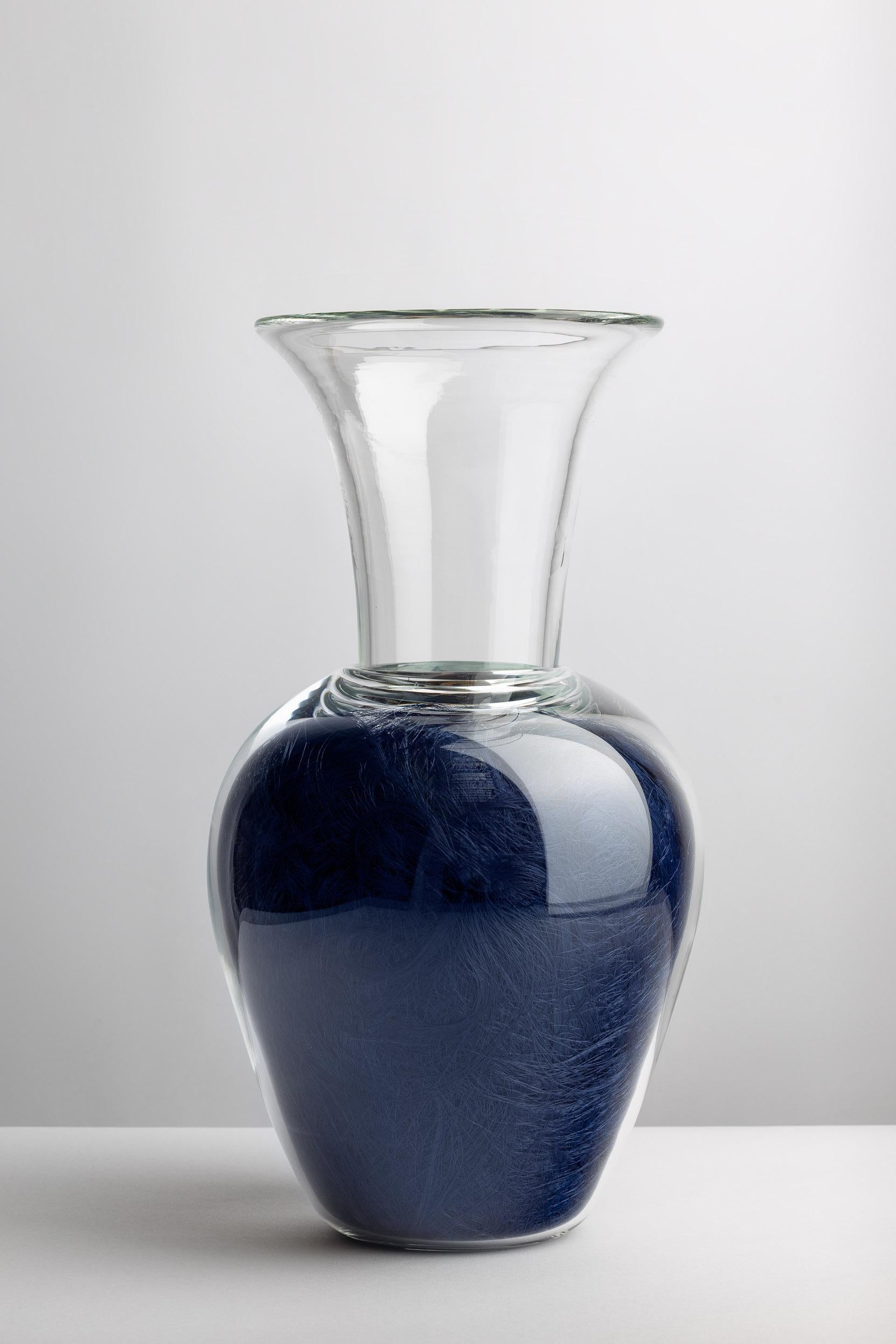 Blue might be the color of the sea, yet, if contaminated by pollutants it can change hue. VELENI’s Vase VA2-20eb serves the purpose of keeping plants and flowers alive, plants that however, are surrounded by sinuous microfibers that seem to mimic