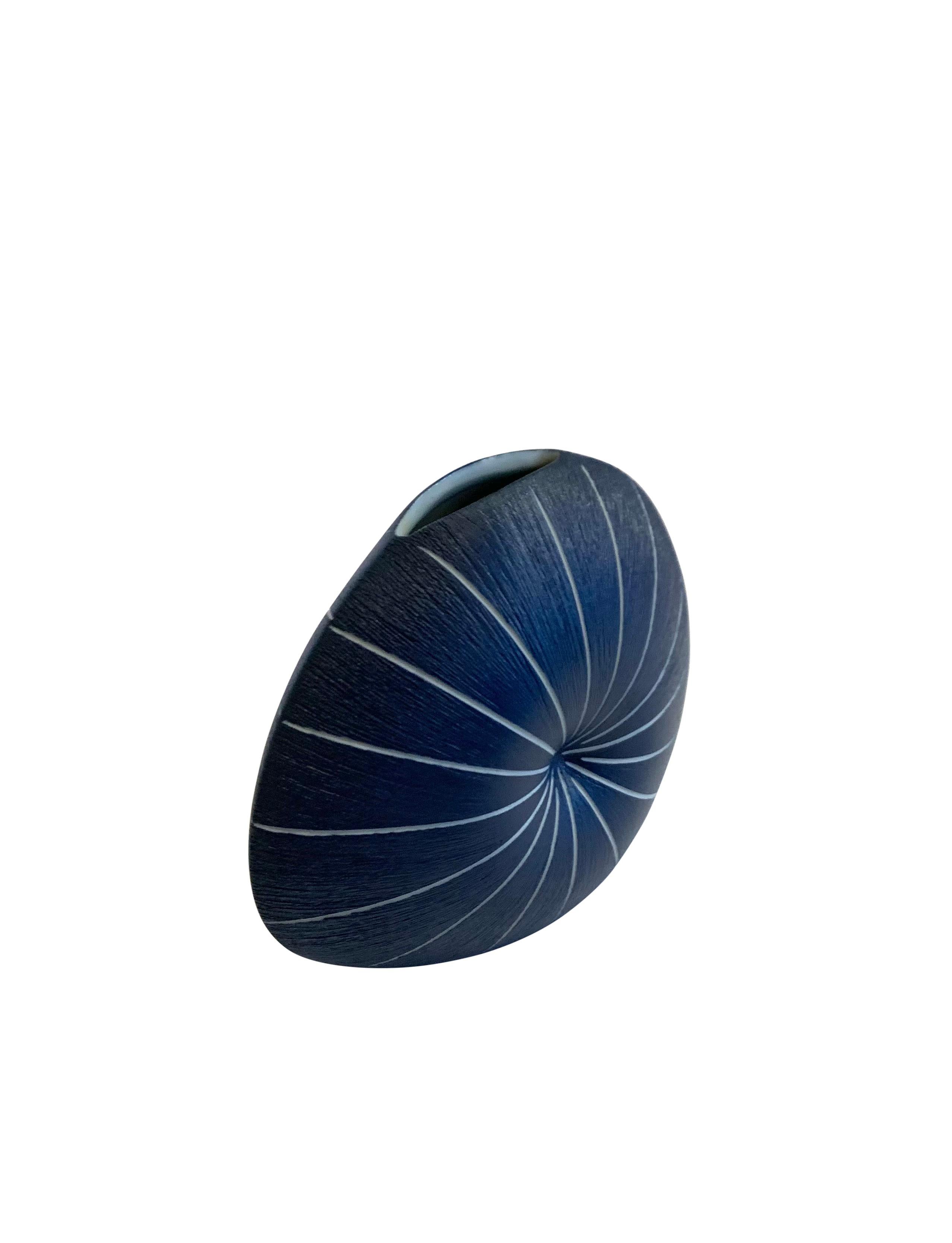 Contemporary Thailand dark blue and white striped vase.
Starburst pattern design in a round shape.
Indent in the center creates the starburst pattern.
Can hold water.
Larger size also available ( S5853 )
Part of a collection of unusually shaped